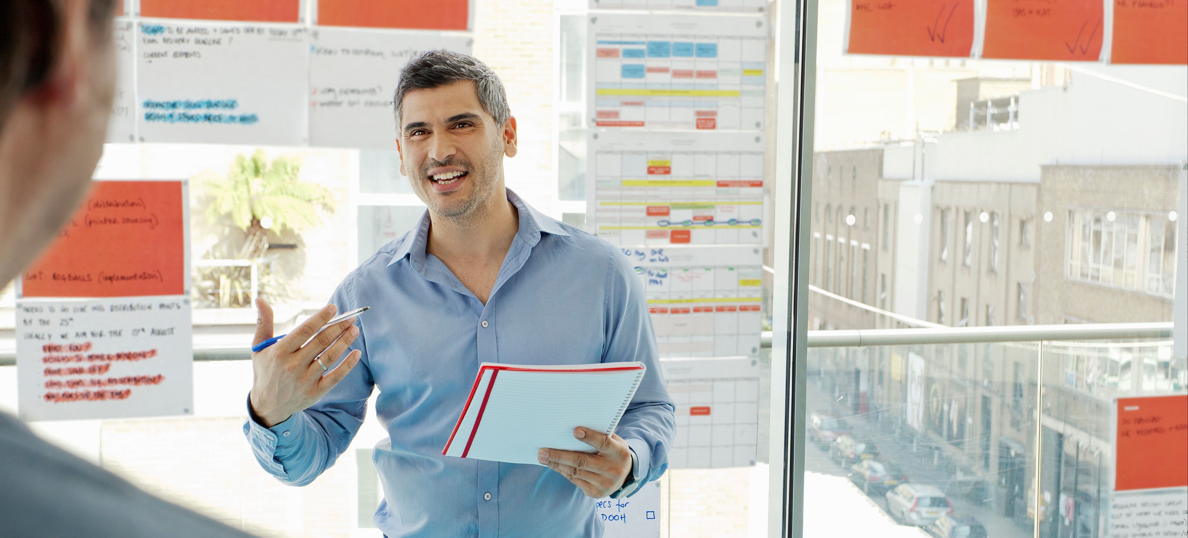 [Hauptbild] Ein Projektmanager bespricht mit einem Kollegen den Lebenszyklus eines Projekts.