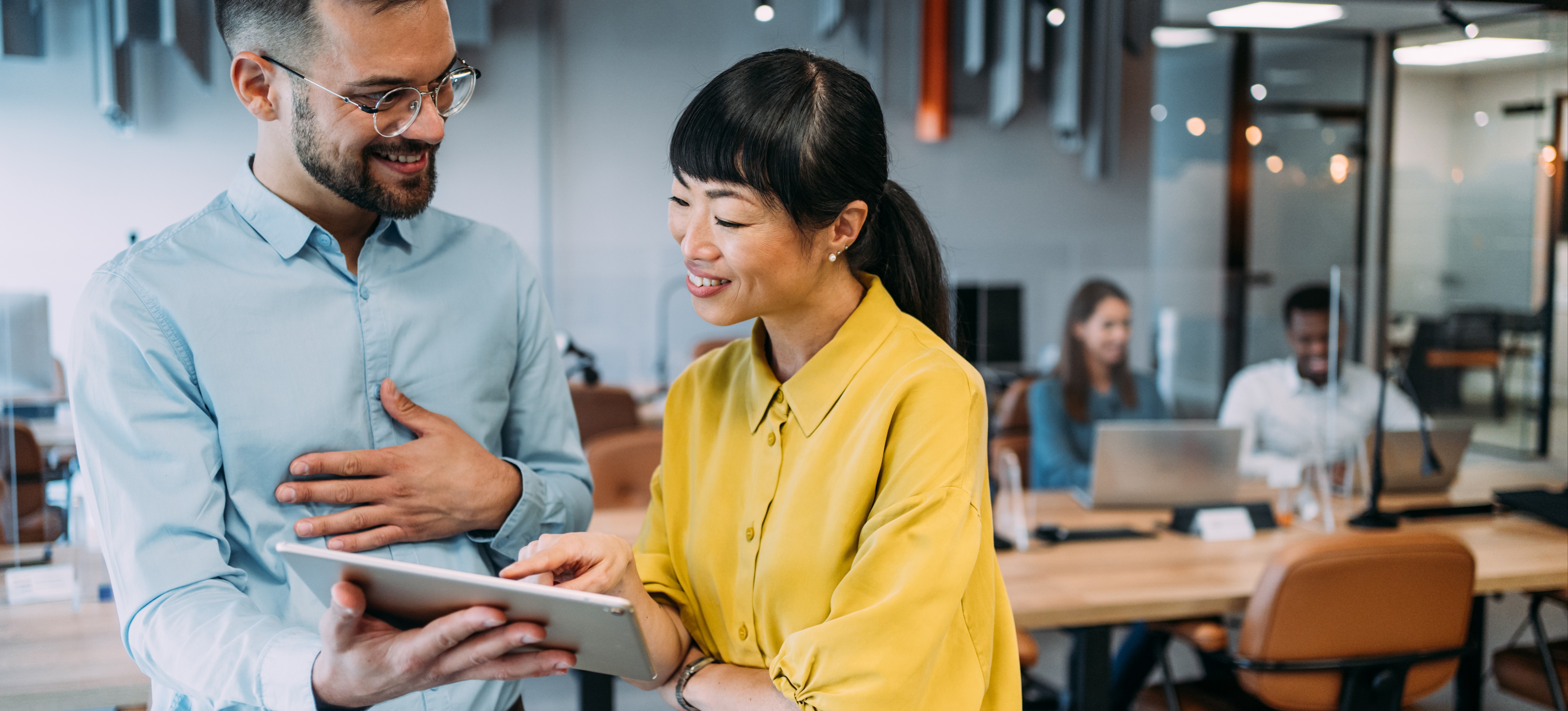 [Hauptbild] Ein lächelnder Manager unterhält sich mit einem lächelnden Mitarbeiter, um eine positive Mitarbeitererfahrung zu schaffen.
