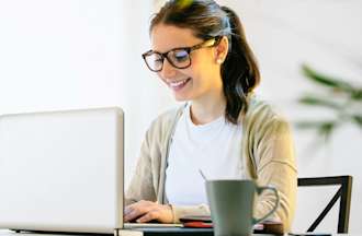 [Featured Image] A programmer sits at a desk and uses a laptop application that includes lexical analysis. 