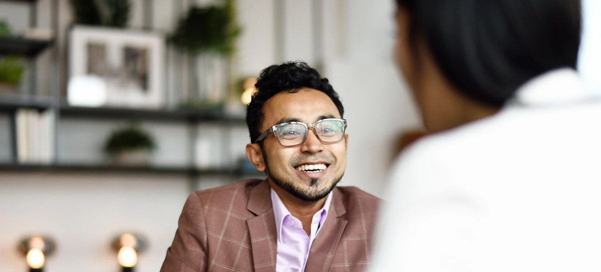 [Featured Image]:  An accountant, discussing with their co-worker going over the financial books of their small business. 