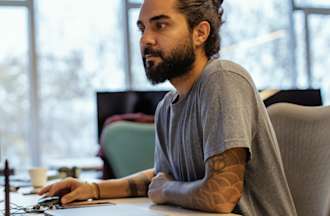 [Featured image] A site reliability engineer (SRE) works on his desktop computer.