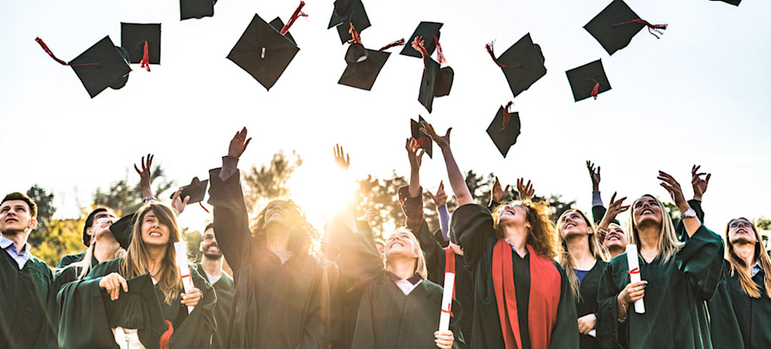 [Featured Image] College students smiling in their graduation gowns and tossing their caps in the air after choosing the right degree and graduating successfully. 
