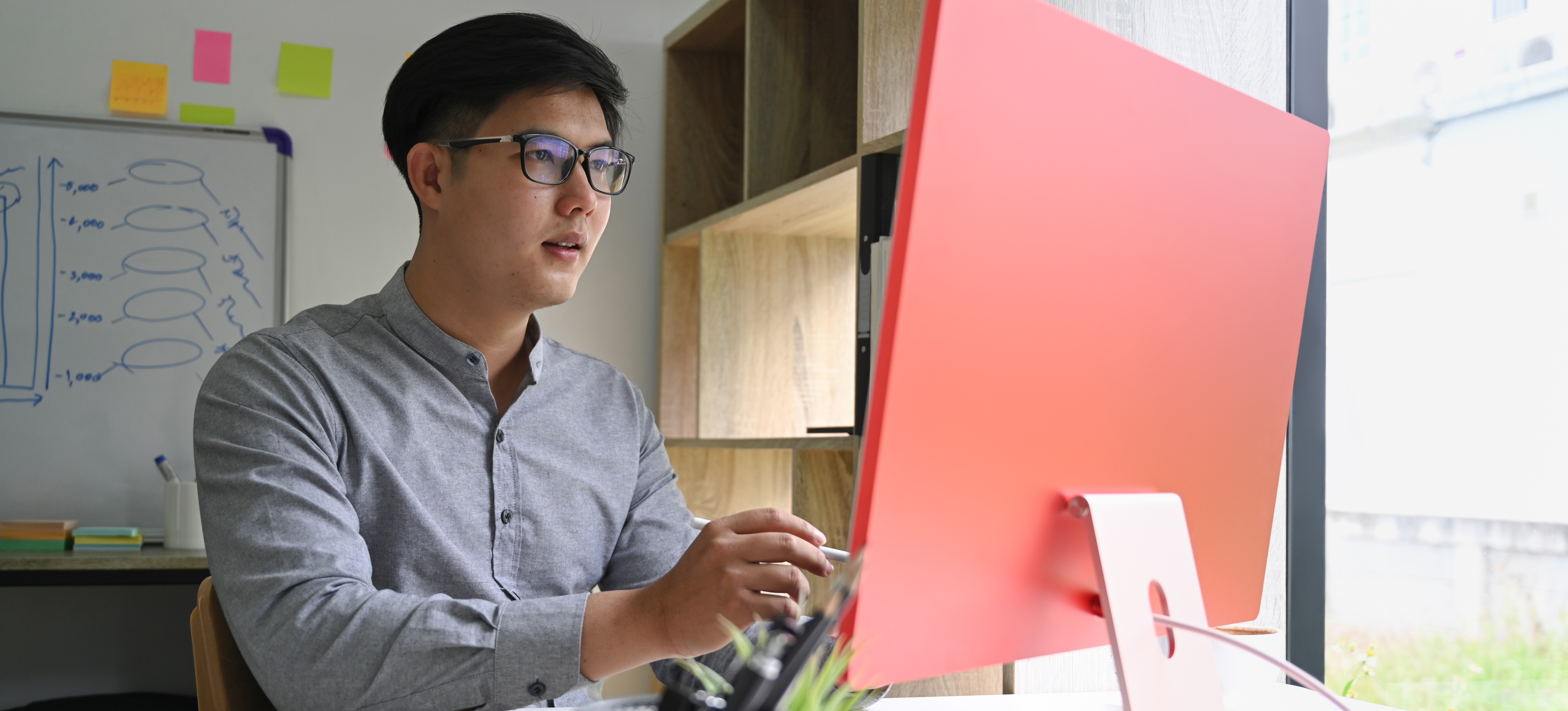 [Image en vedette] Un professionnel de la technologie dans un bureau recherche sur le Web la réponse à la question : « Qu'est-ce qu'ITIL ? »