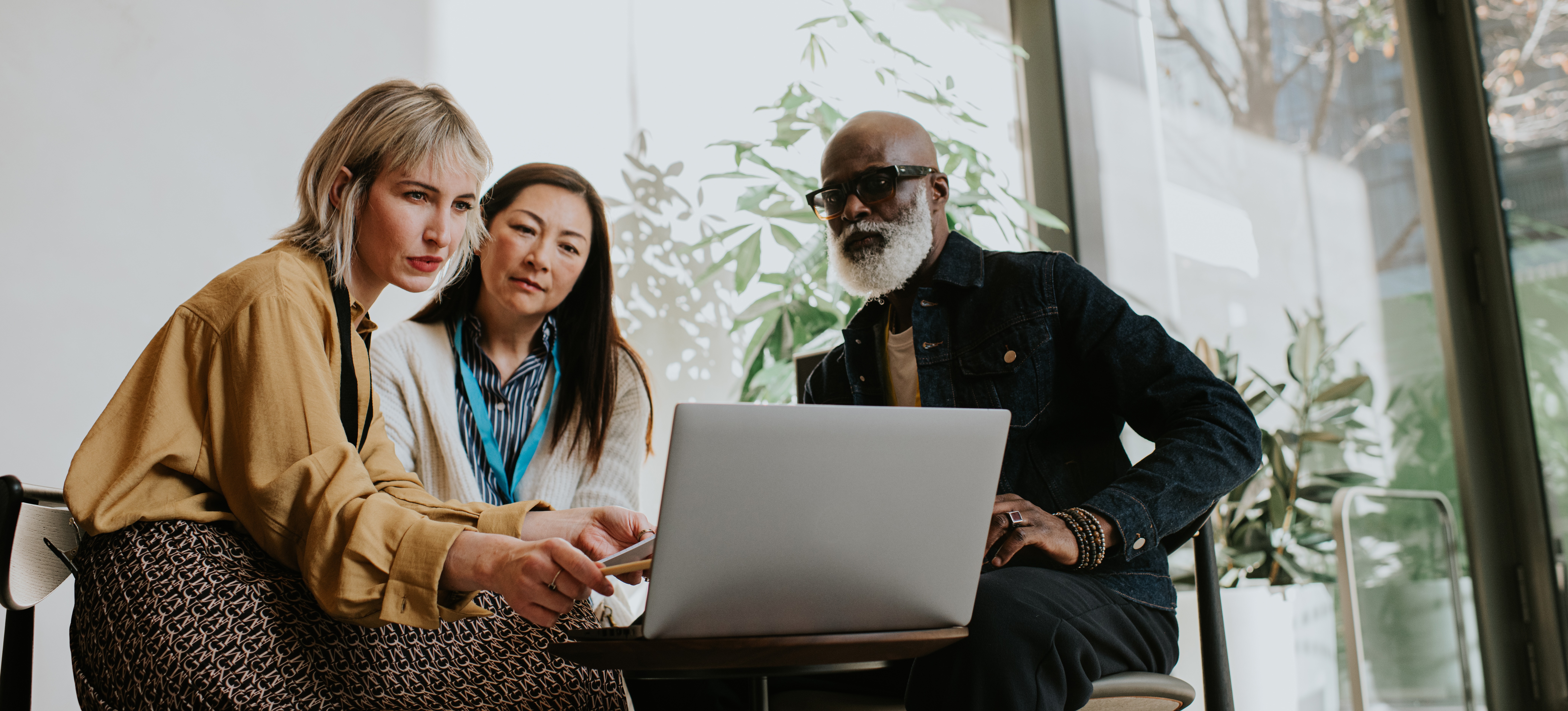 [Featured image]: A person with a laptop using their sales skills to recommend AI tools to two clients.
