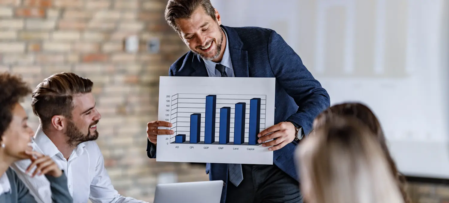 [Featured Image] A financial risk manager discusses financial risk management strategies with the team in a professional workplace setting.
