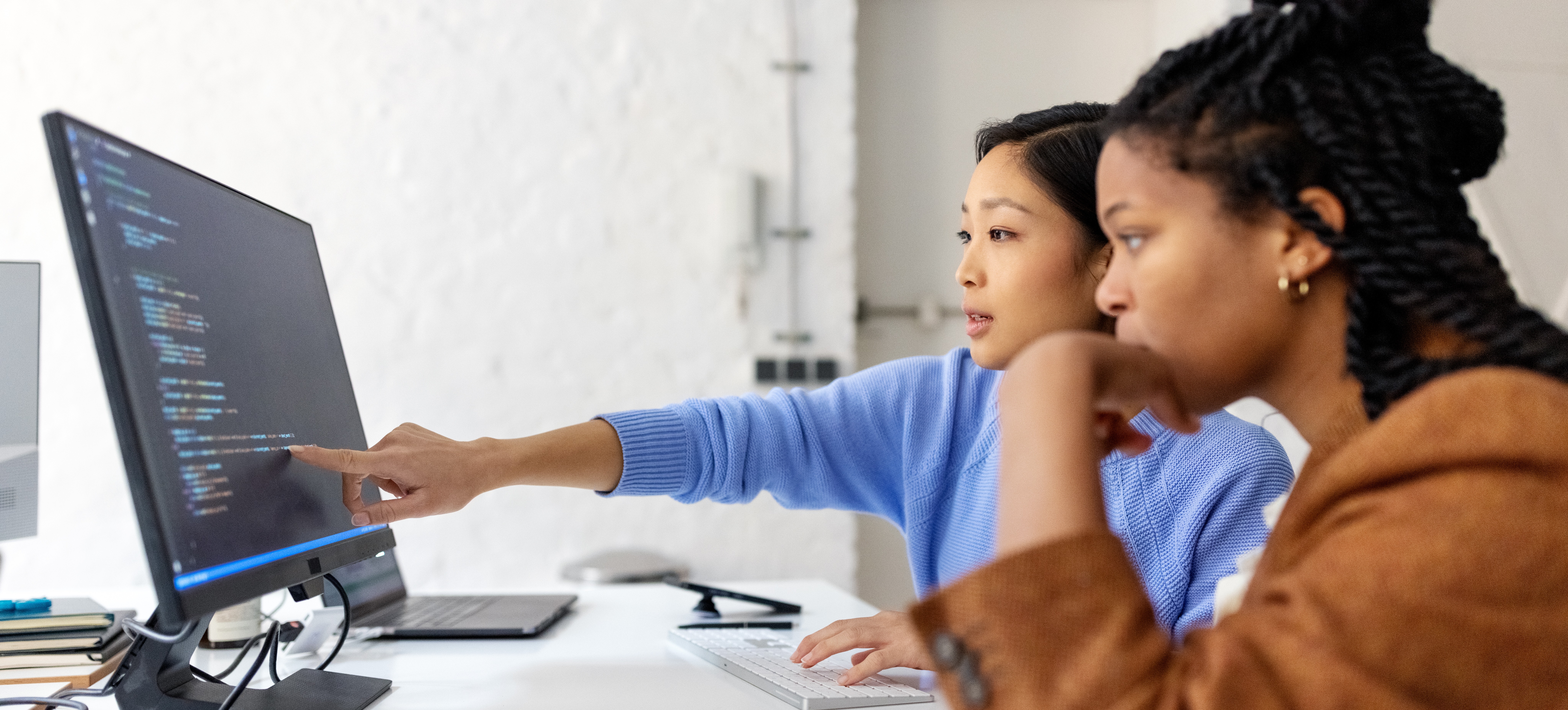 [Featured image] Two machine learning colleagues working with NLP algorithms in an office.