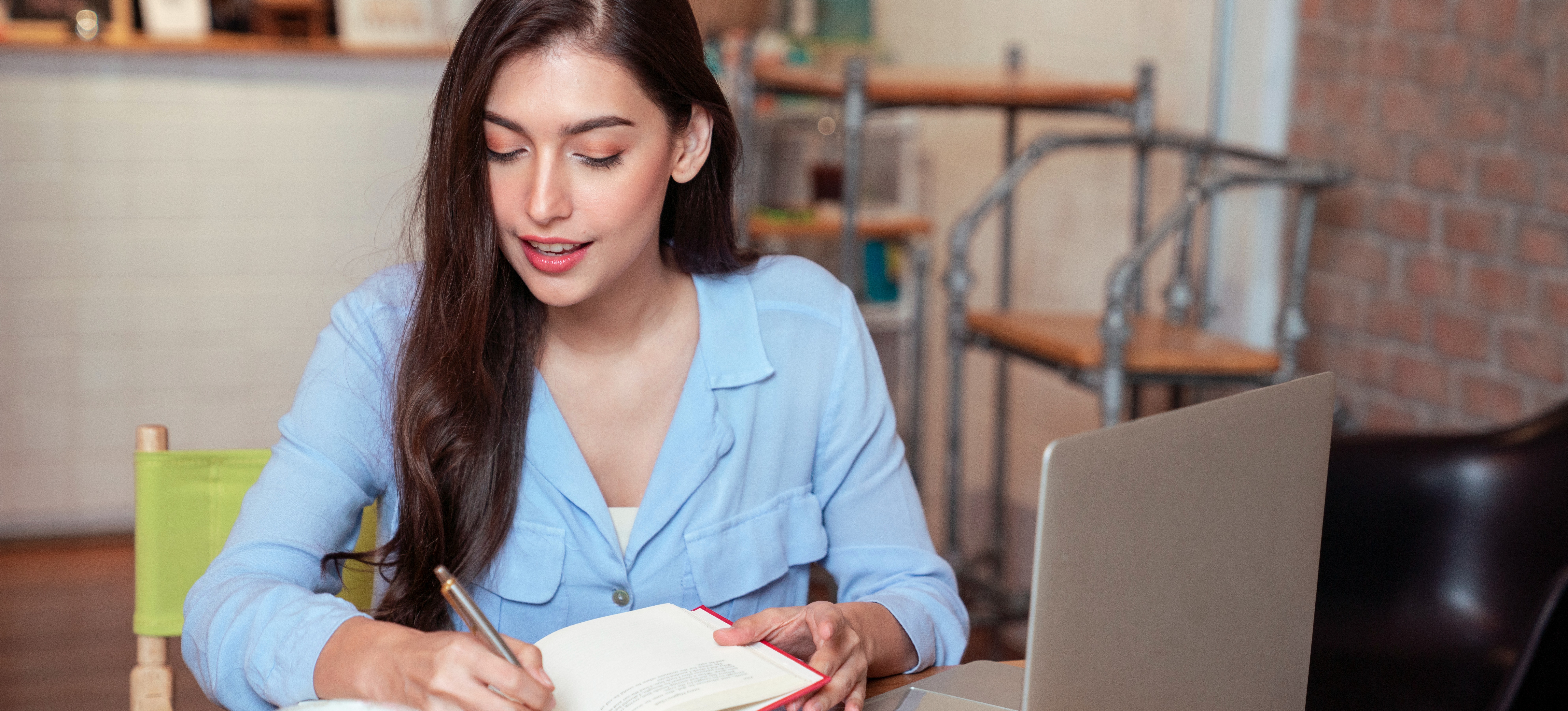 [Featured Image] A learner sits at a table with a laptop and notebook, studying for a bachelor’s degree from a community college.
