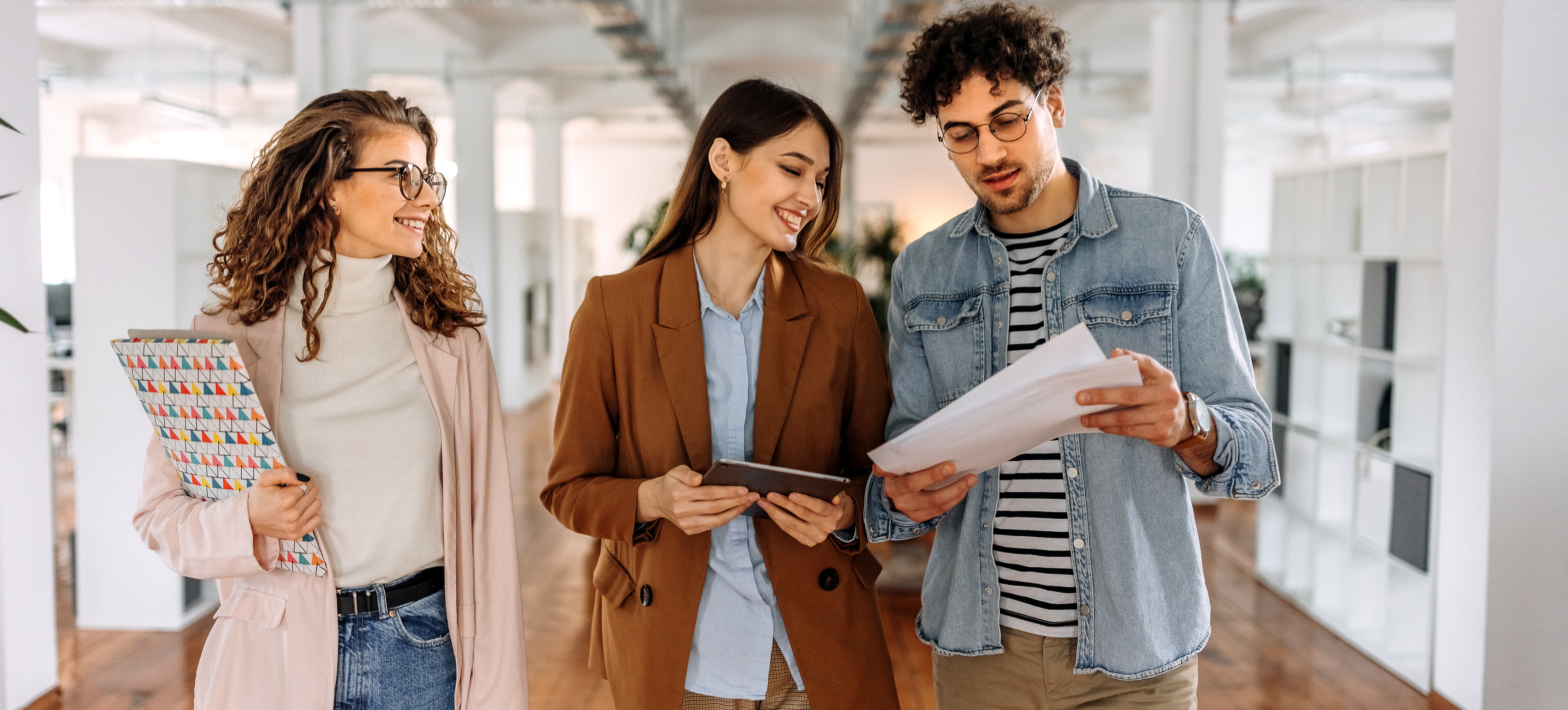 [Featured Image] Two young professionals shadow a professional mentor during their practicum as they learn about job responsibilities in a particular field.
