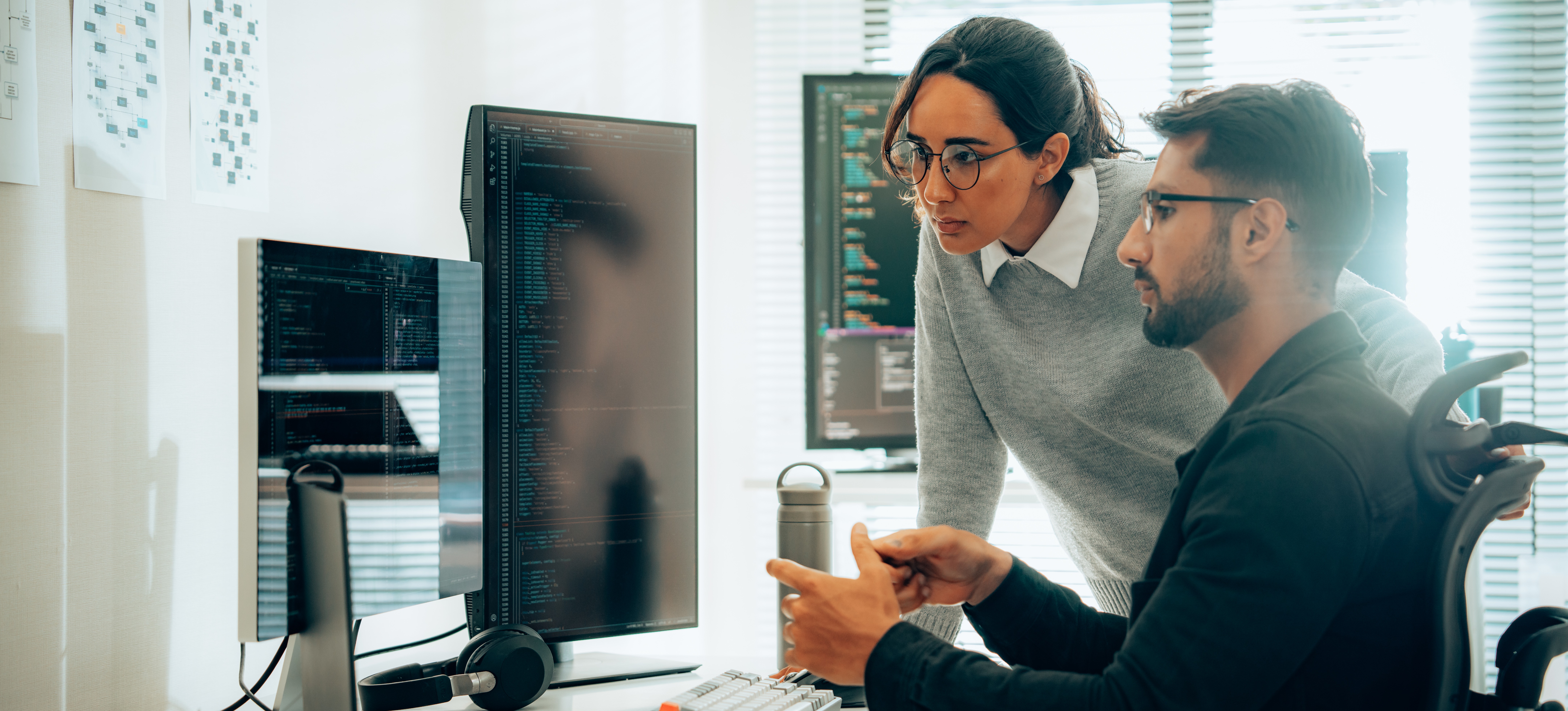 [Hauptbild] Zwei Cybersicherheitsanalysten diskutieren Schwachstellen im System ihrer Organisation und wie Hackerangriffe verhindert werden können.