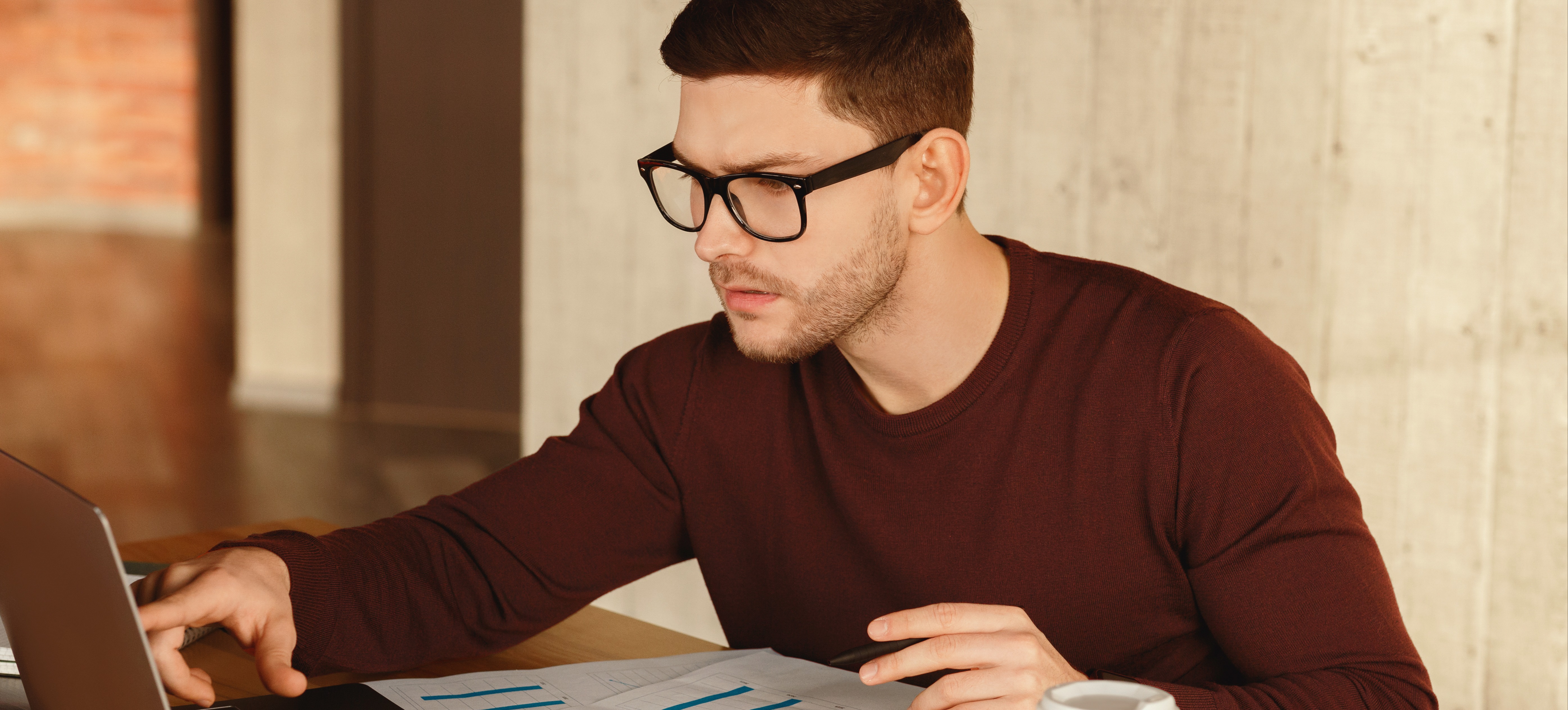 [Featured Image] A data scientist works on a laptop and examines data visualizations, using Bayesian hierarchical modeling to extract insights.
