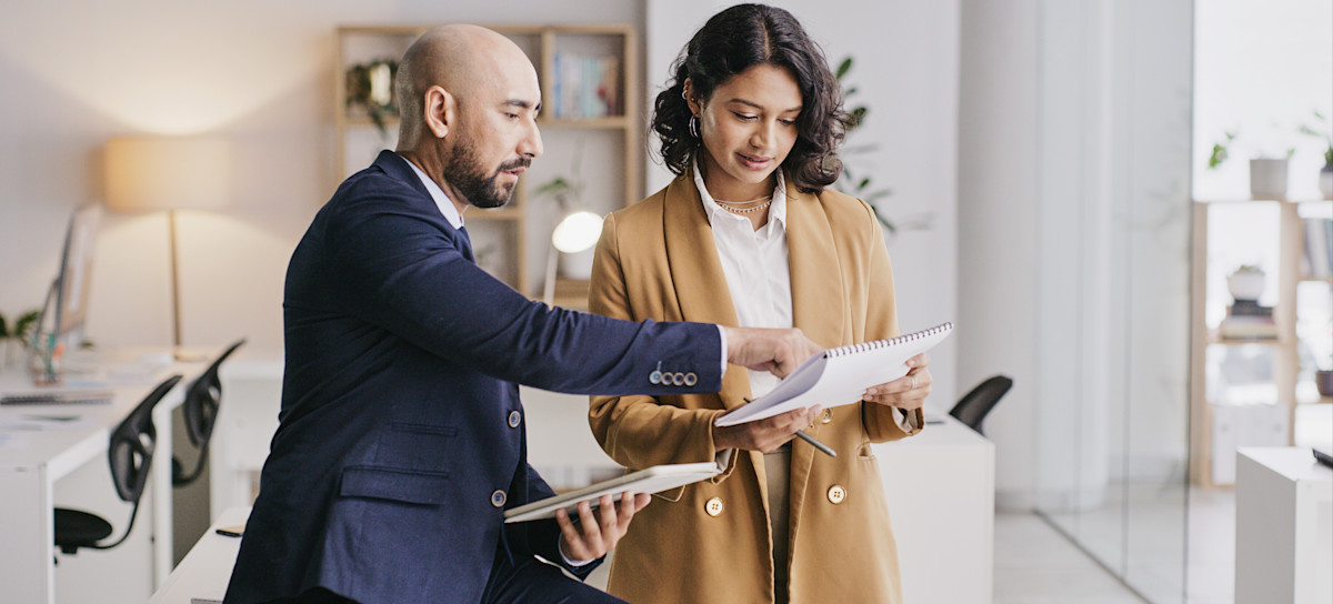 [Featured Image] A project manager and designer meet to discuss the customer experience (CX) strategy they will implement for their latest product.
