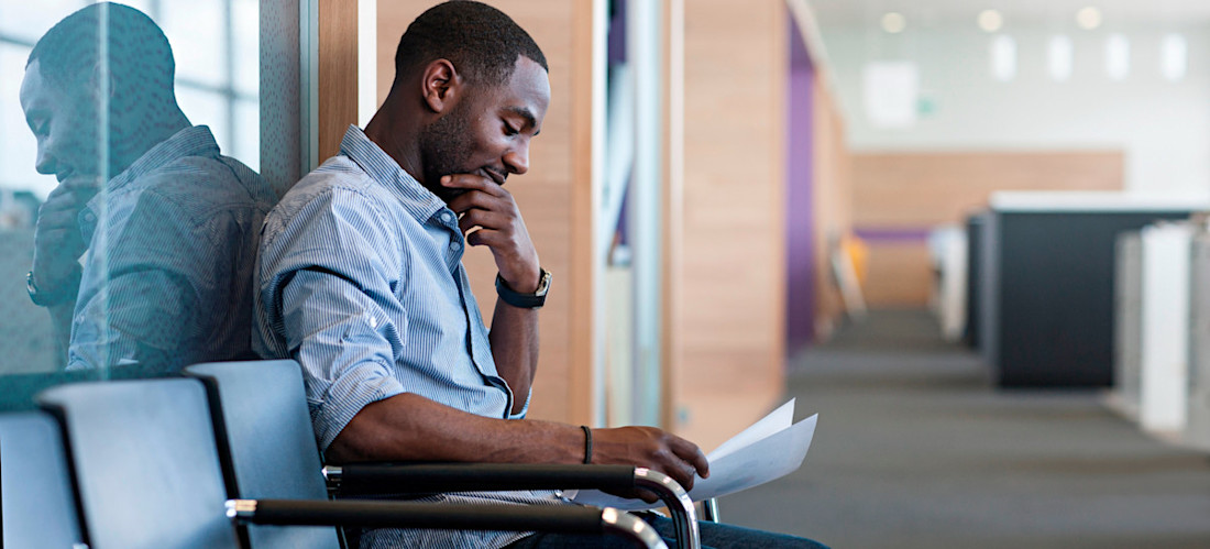 [Featured image] A man sits in a hallway preparing responses for common interview questions.