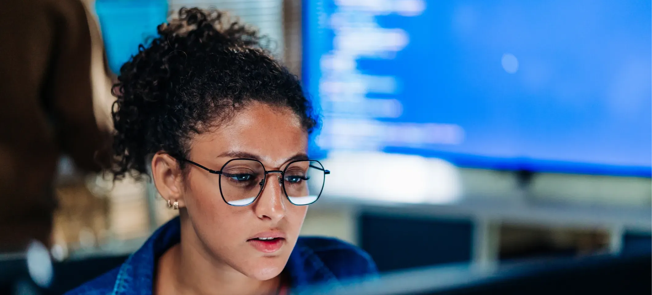 [Featured Image] A data analyst using an OLS regression model looks at a computer screen in a data center.
