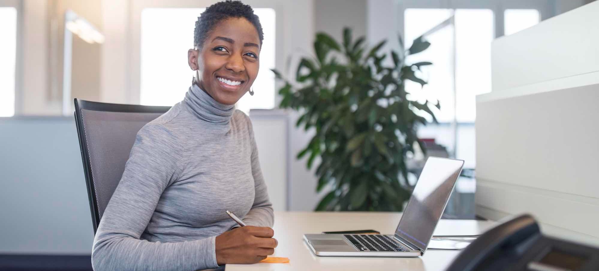 [Featured image] A software developer in a blue sweater sits at a desk with a laptop, tablet, and a stack of sticky notes.