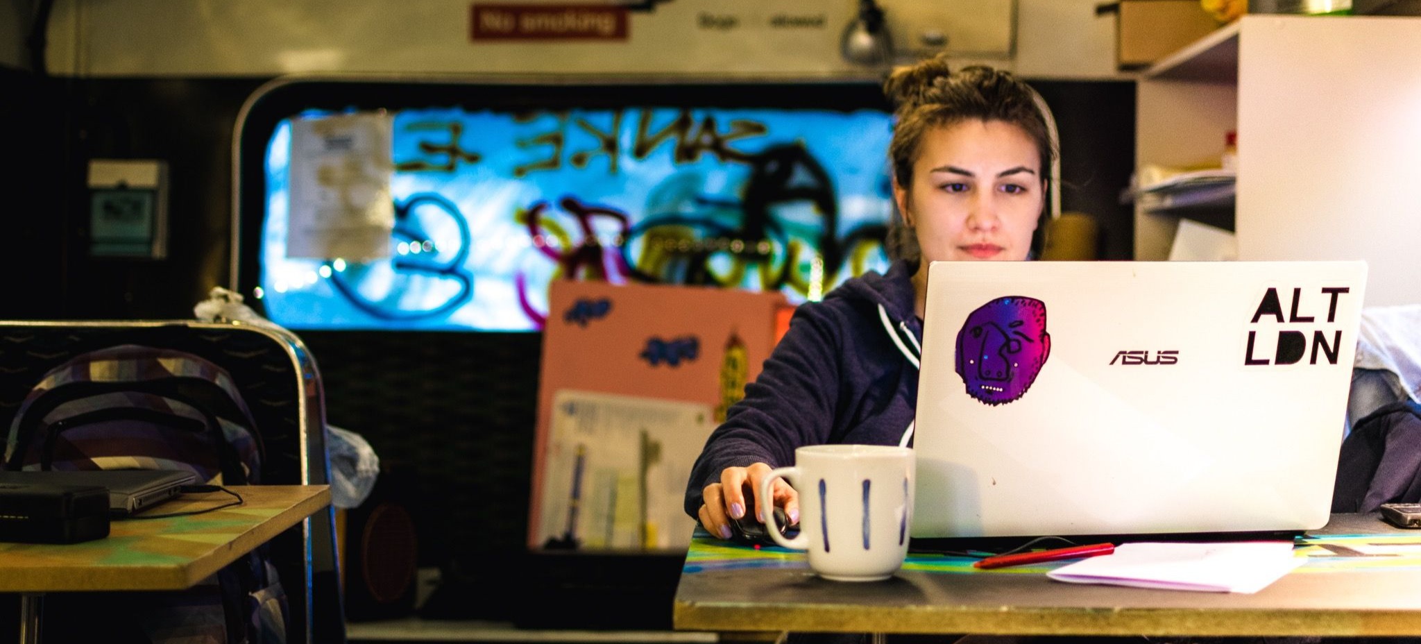 [Featured Image] A transfer student is sitting at a desk using their laptop.  