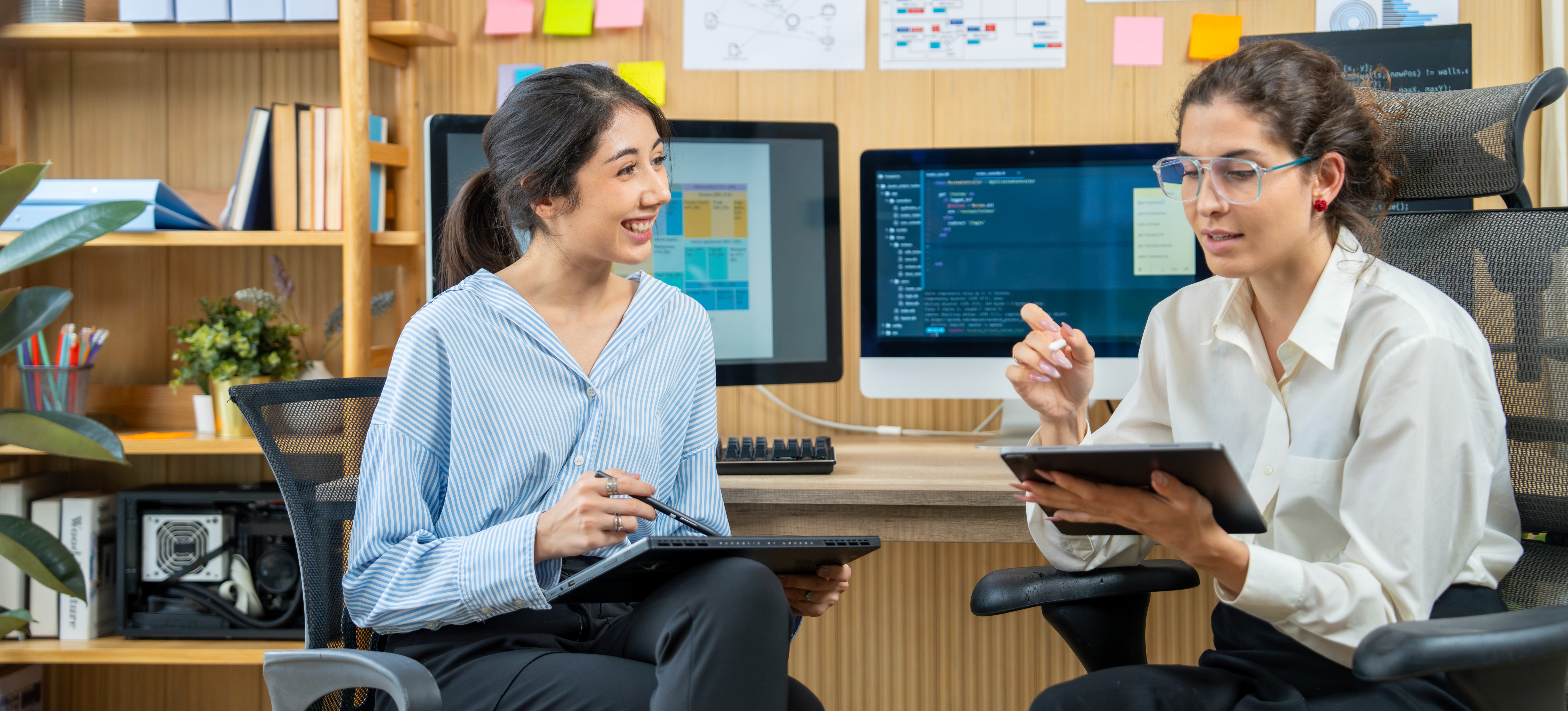 [Featured Image] A UX researcher sits in an office space, conducting an interview with a user.
