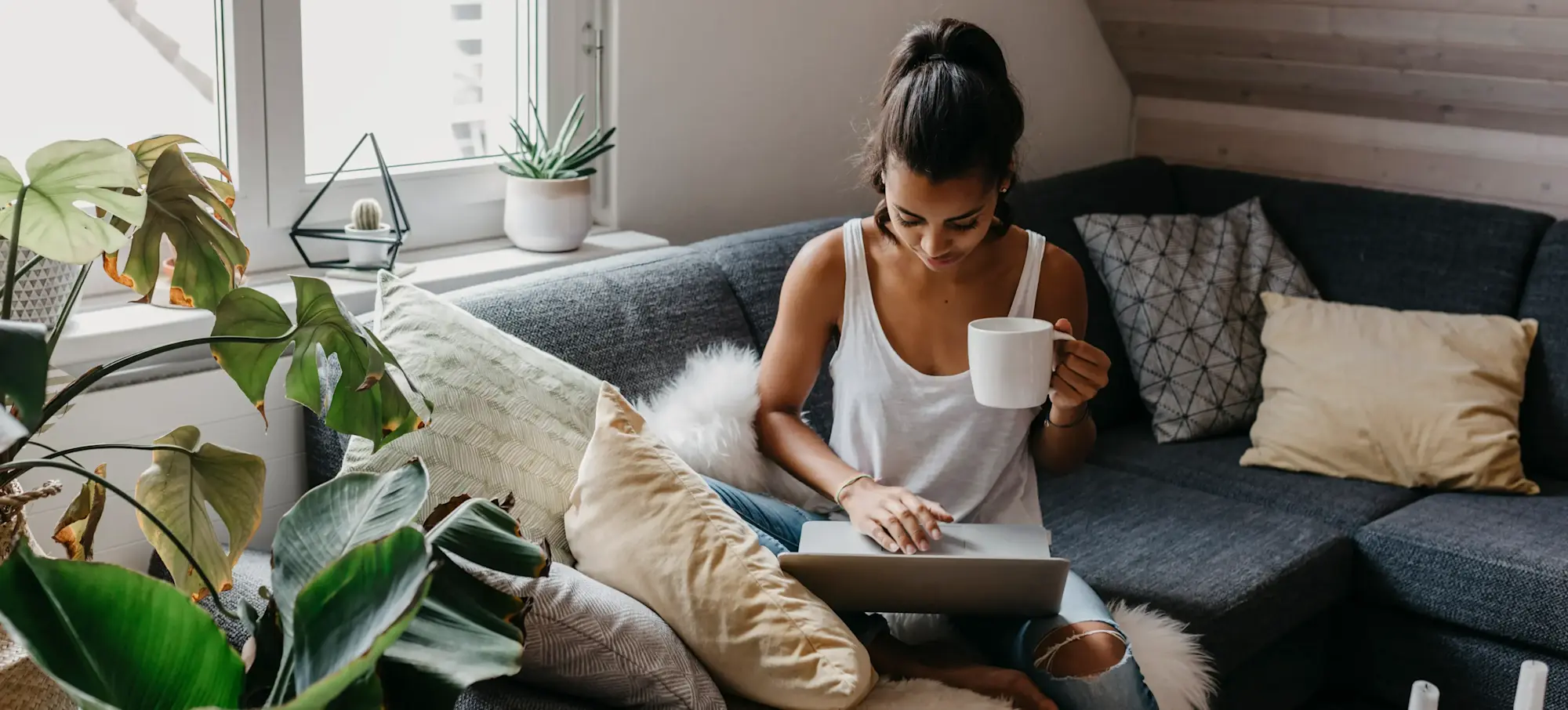 [Featured Image] Woman sitting on a couch working on a laptop, comparing ChatGPT and Google Search for research, writing, and everyday tasks.