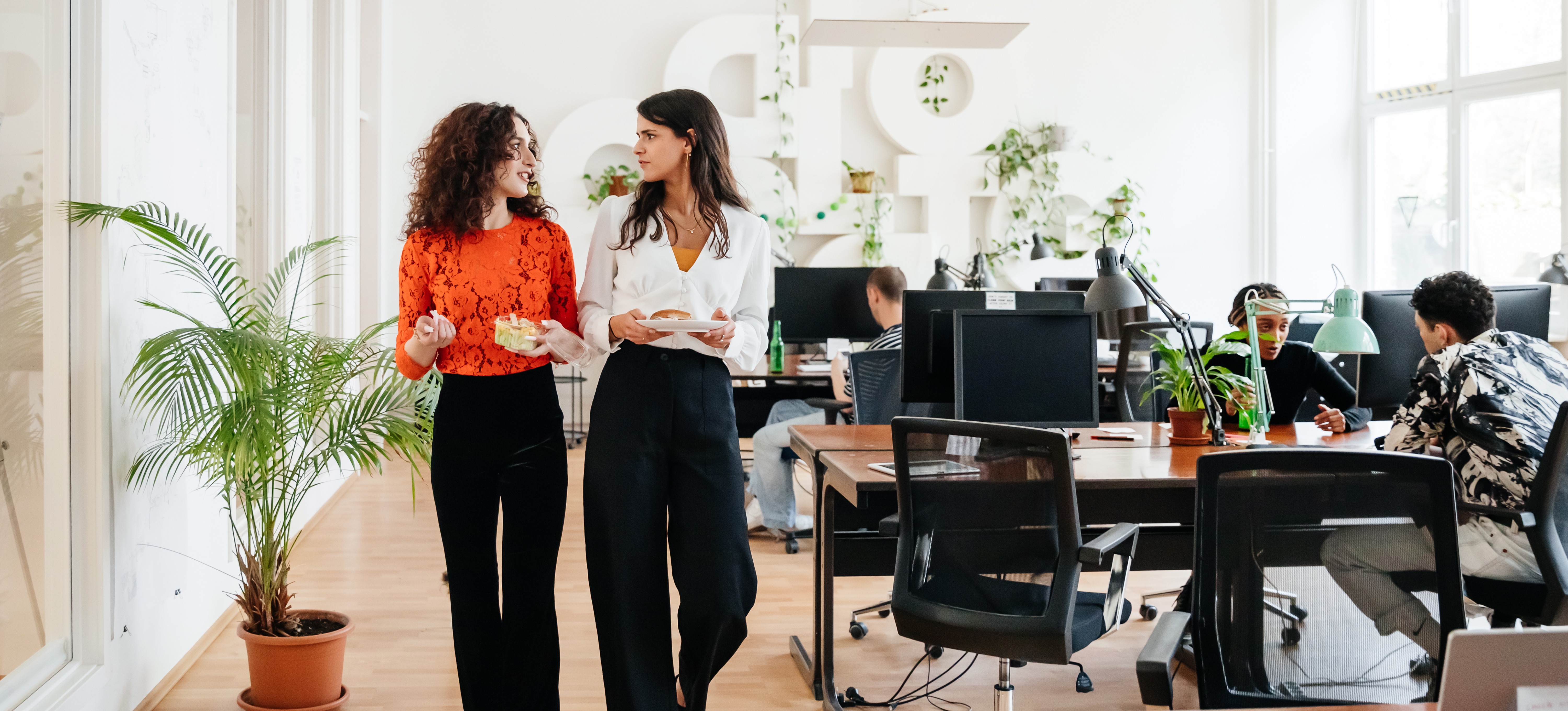 [Feature Image] Two data scientists discuss Jupyter vs. Zeppelin while walking from the break room through the office to return to their desks.
