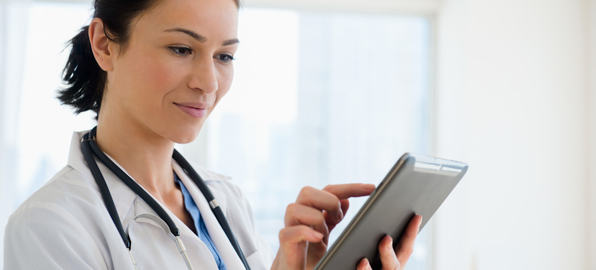 [Featured Image] A doctor uses a generative AI application on their tablet to help with the early detection of disease. 