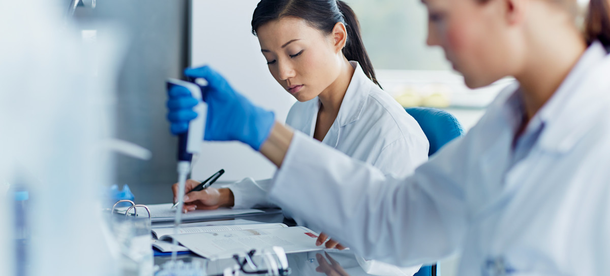 [Featured Image]: Two workers in a laboratory conduct research and work toward becoming famous scientists.
