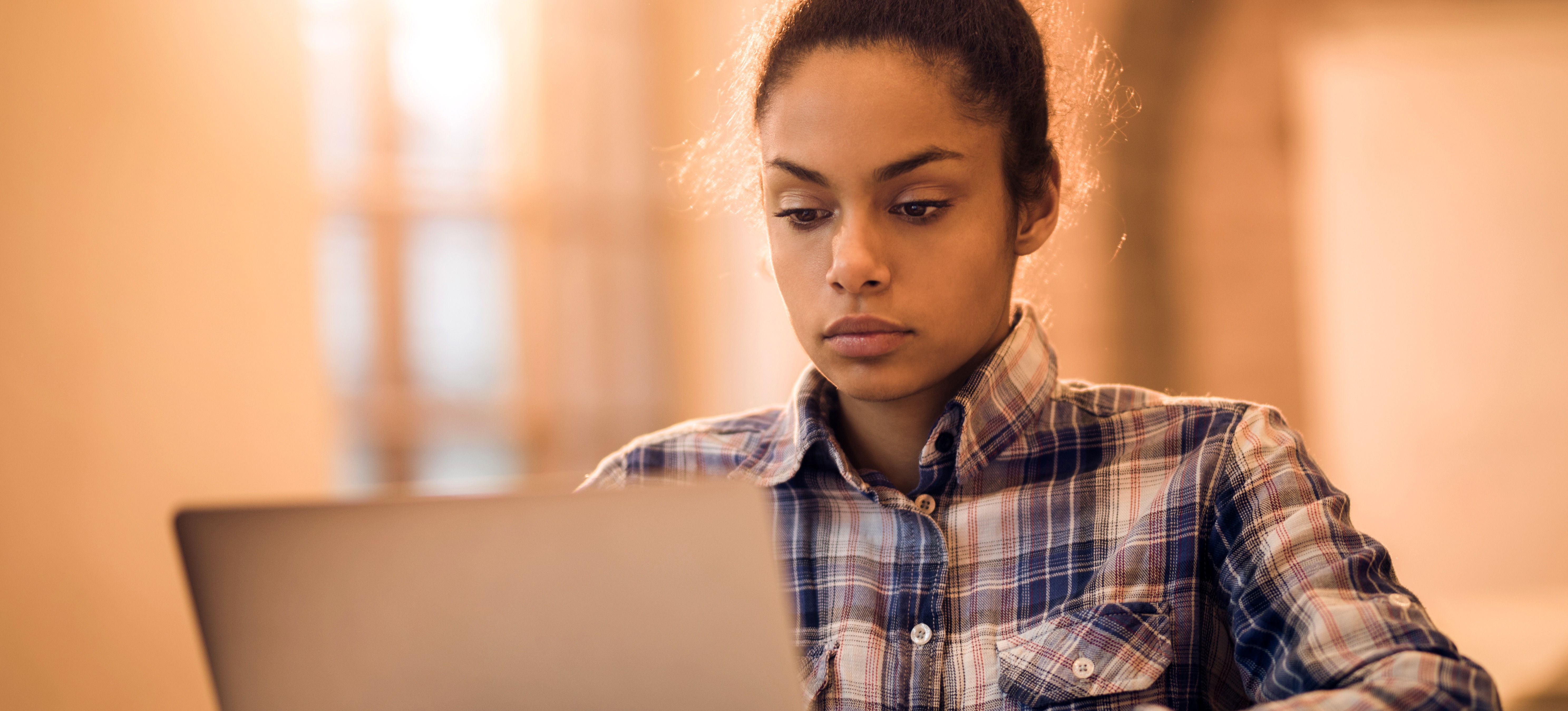 [Featured Image] A web developer is intently working on a laptop.
