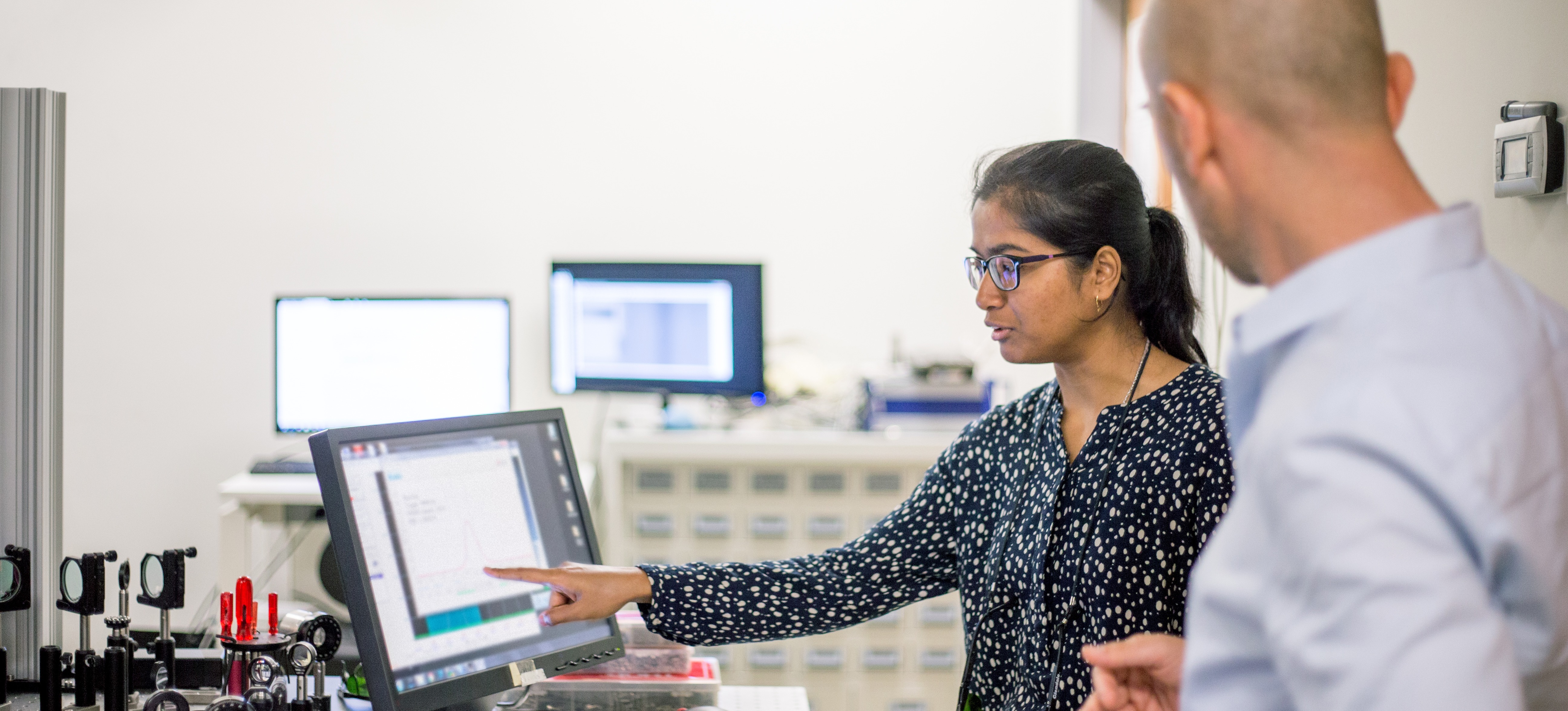 [Featured Image] A member of a product design team discusses the prototype with an engineer.
