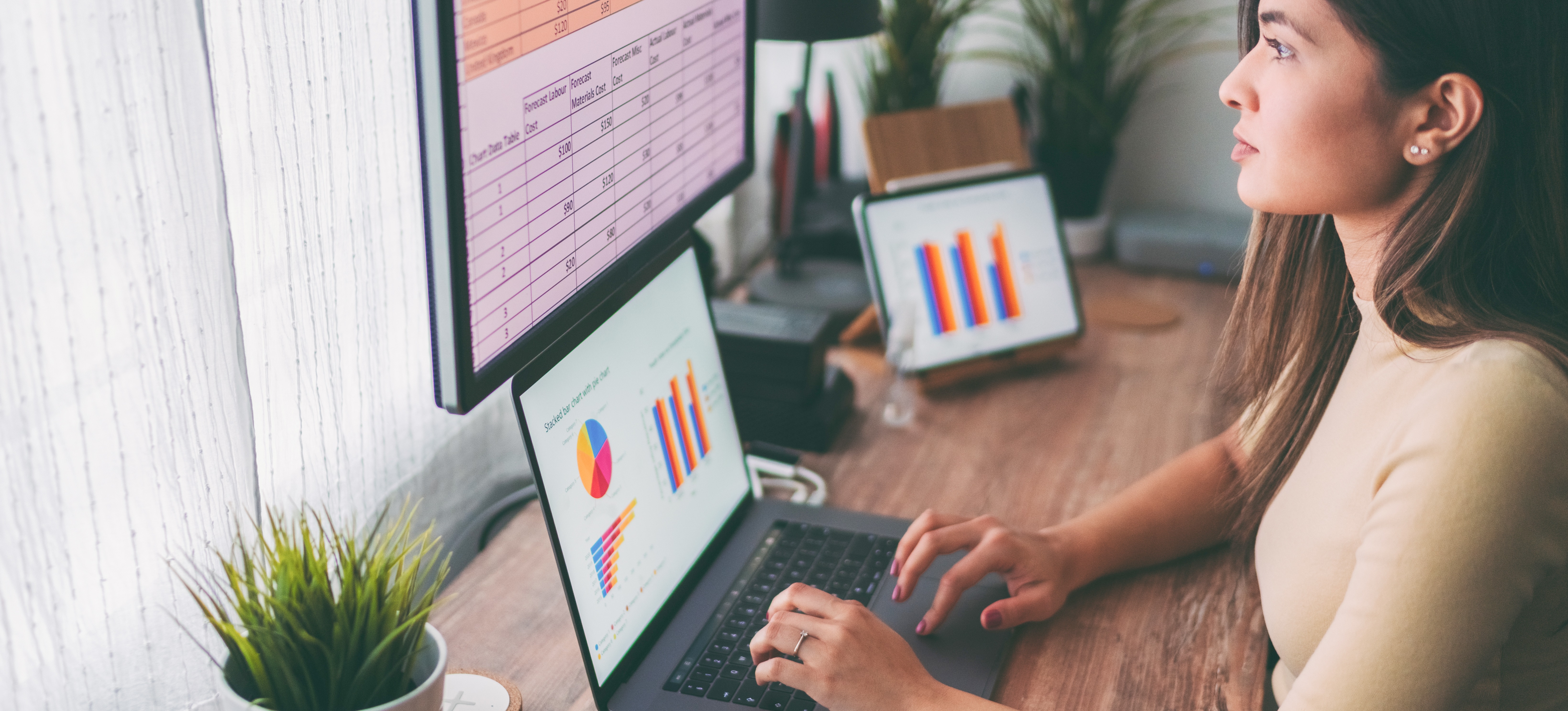 [Featured Image] A woman works at a laptop that is filled with graphs and charts, and that is plugged into one of her solid state drives to save her work.