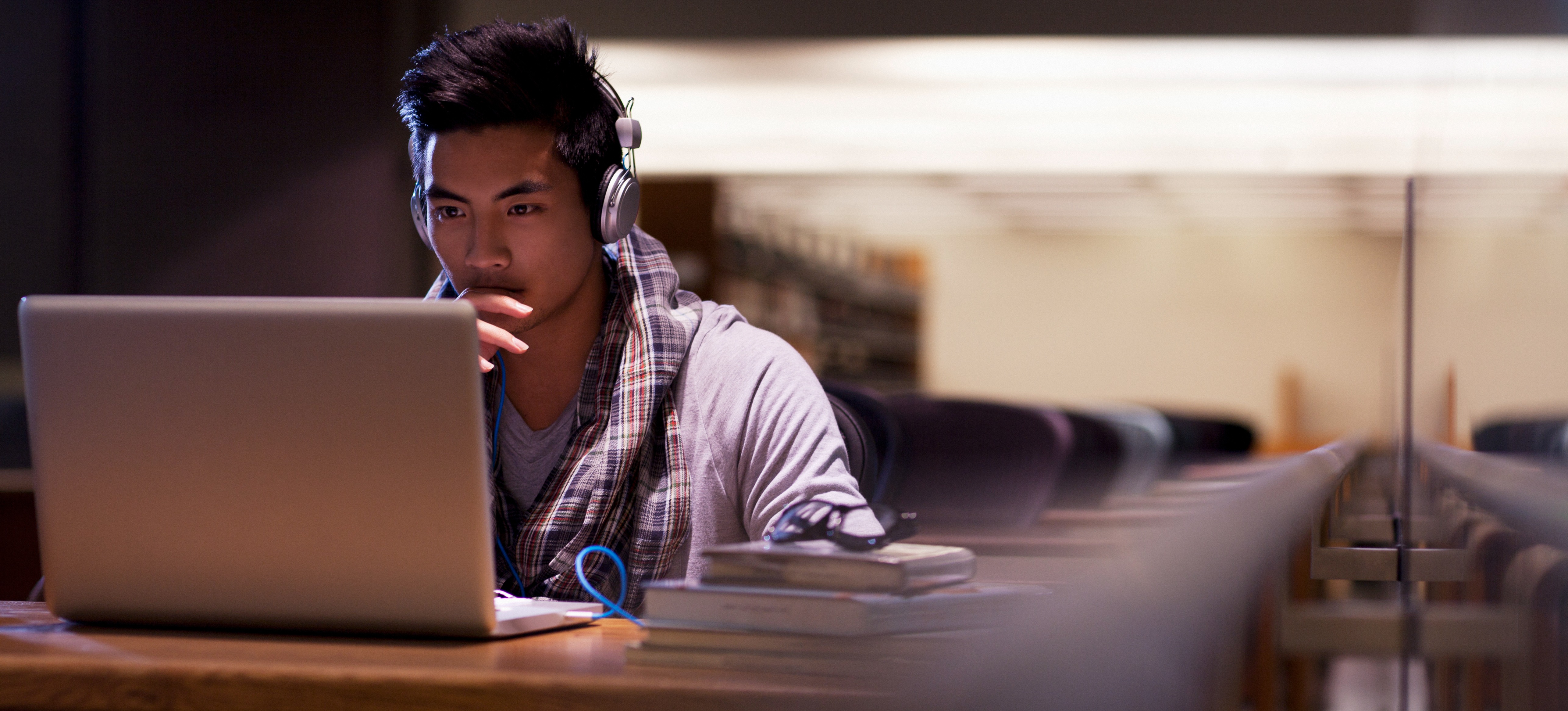 [Image en vedette] Un étudiant utilise différents types de cryptage sur un ordinateur portable dans une bibliothèque.