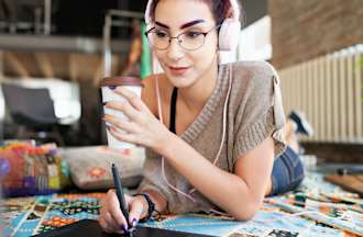 [Featured image] A UX designer sketches on a tablet while drinking a cup of coffee.