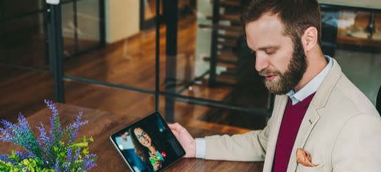 [Featured Image] A man in a suit is on a video call and is looking at applicant tracking system results.