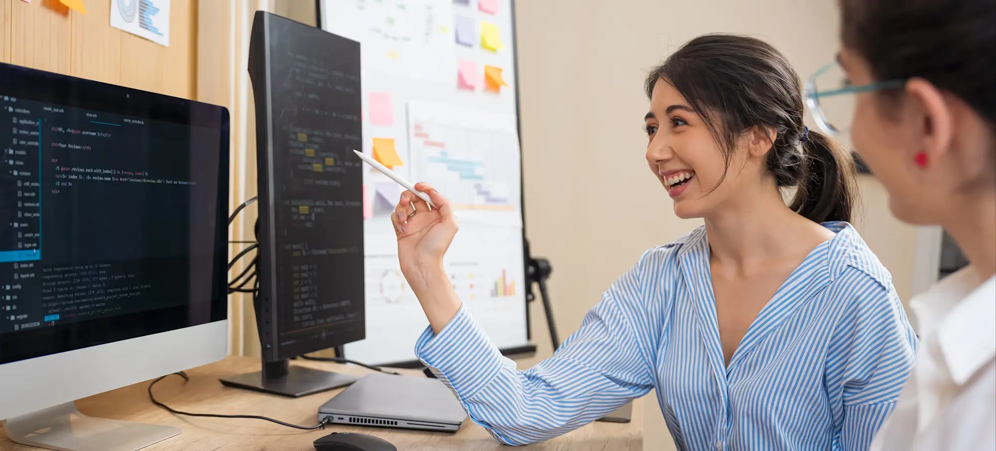 [Featured Image]: A programmer discusses R programming concepts with a colleague in a professional workspace.
