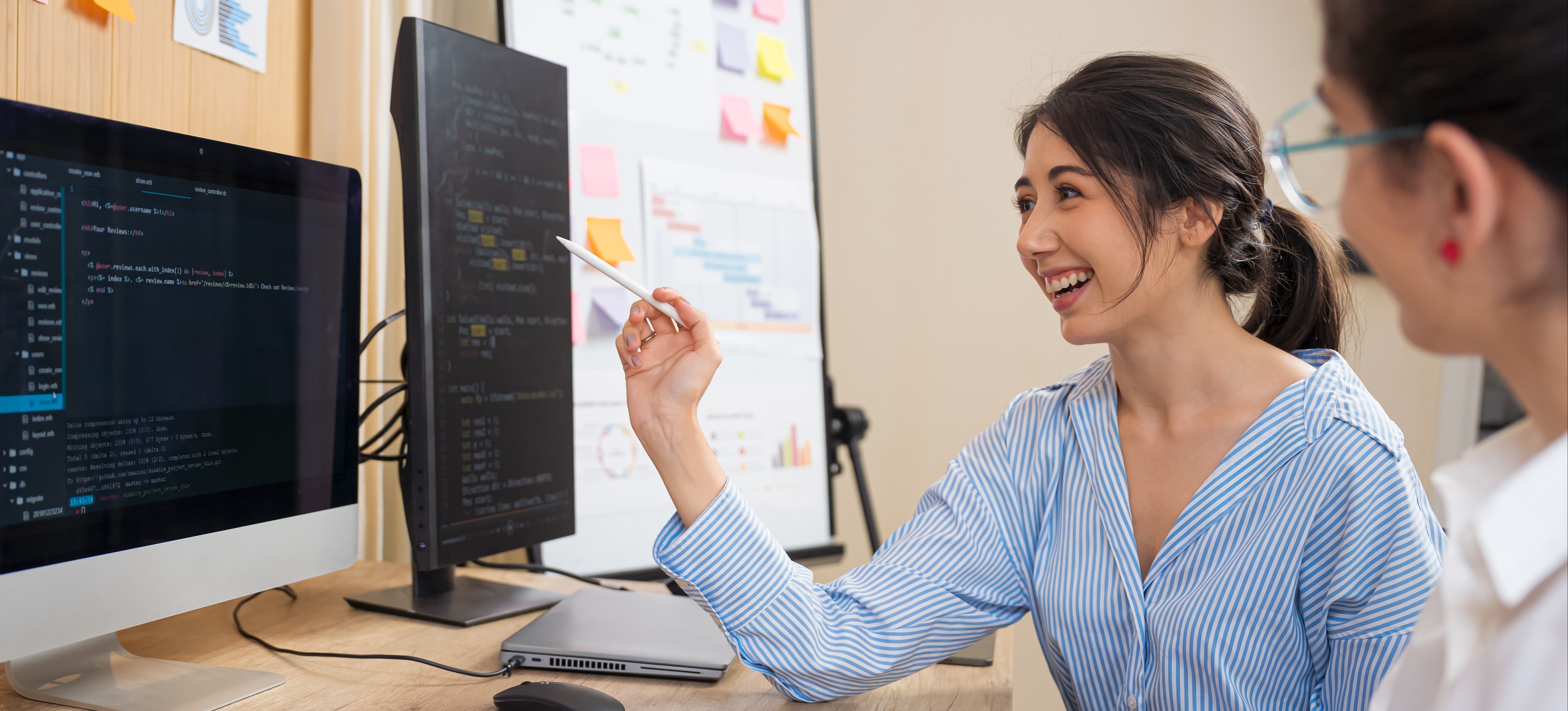 [Featured Image]: A programmer discusses R programming concepts with a colleague in a professional workspace.
