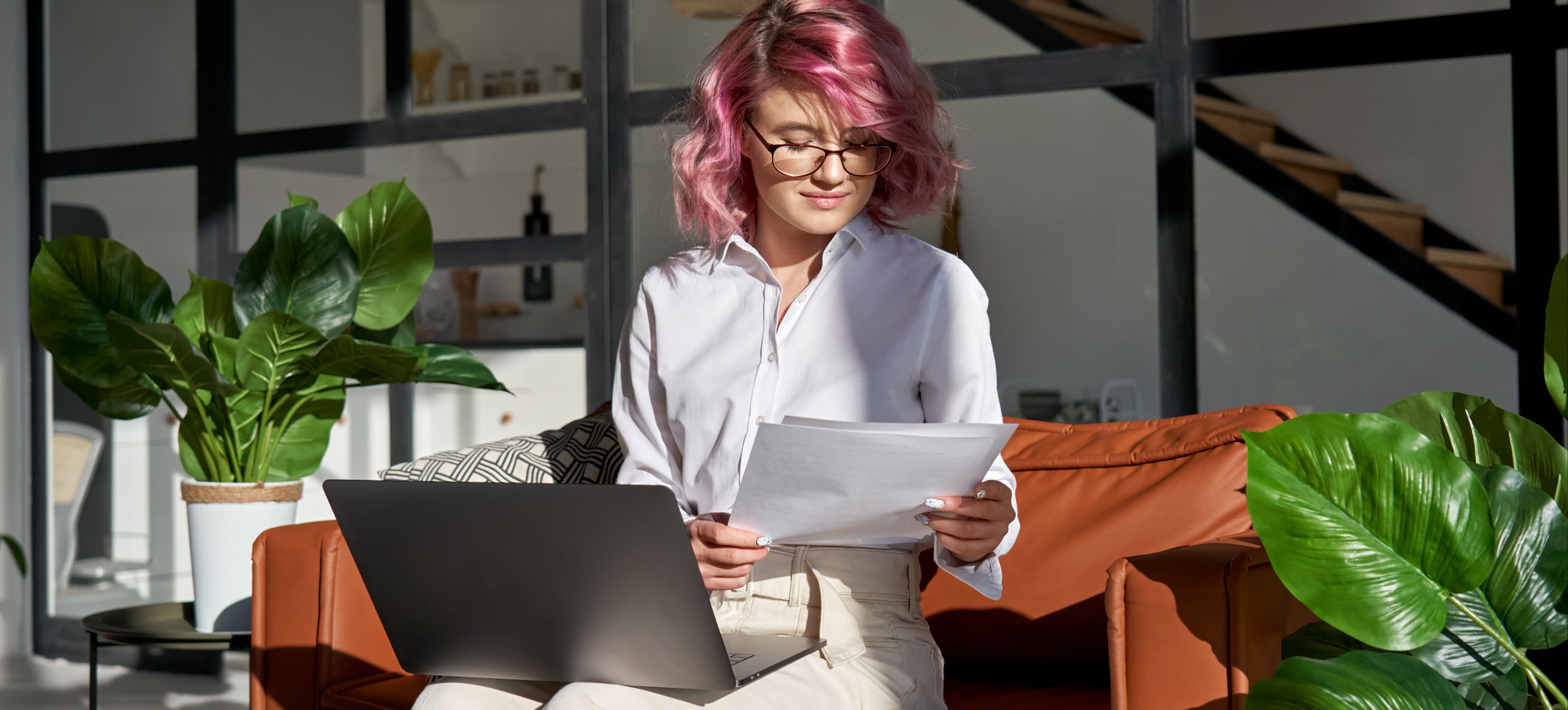 [Featured Image] A learner with pink hair is holding a personal statement with a laptop on their lap.