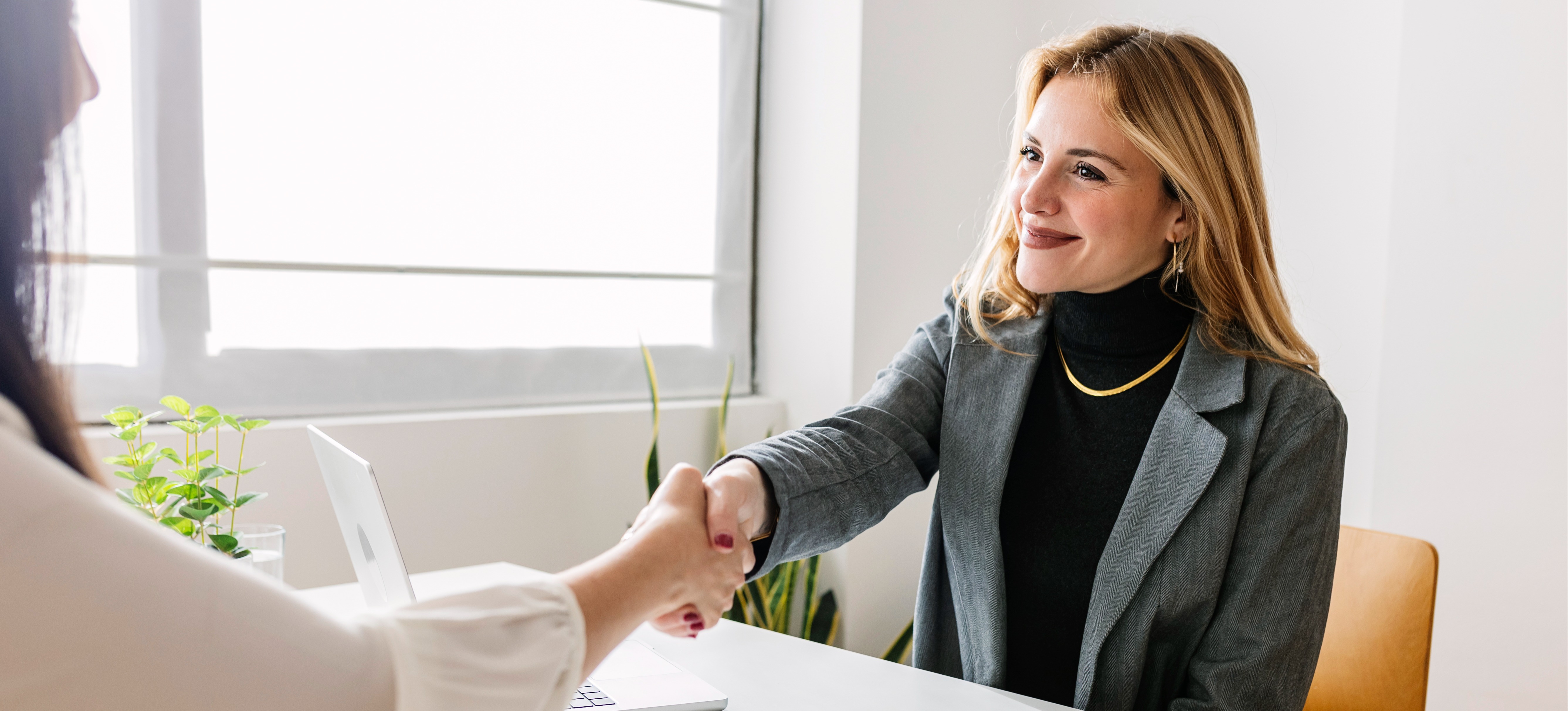 [Feature Image] After researching data center jobs, an aspiring security analyst shakes the hand of a hiring manager at the end of a successful job interview.
