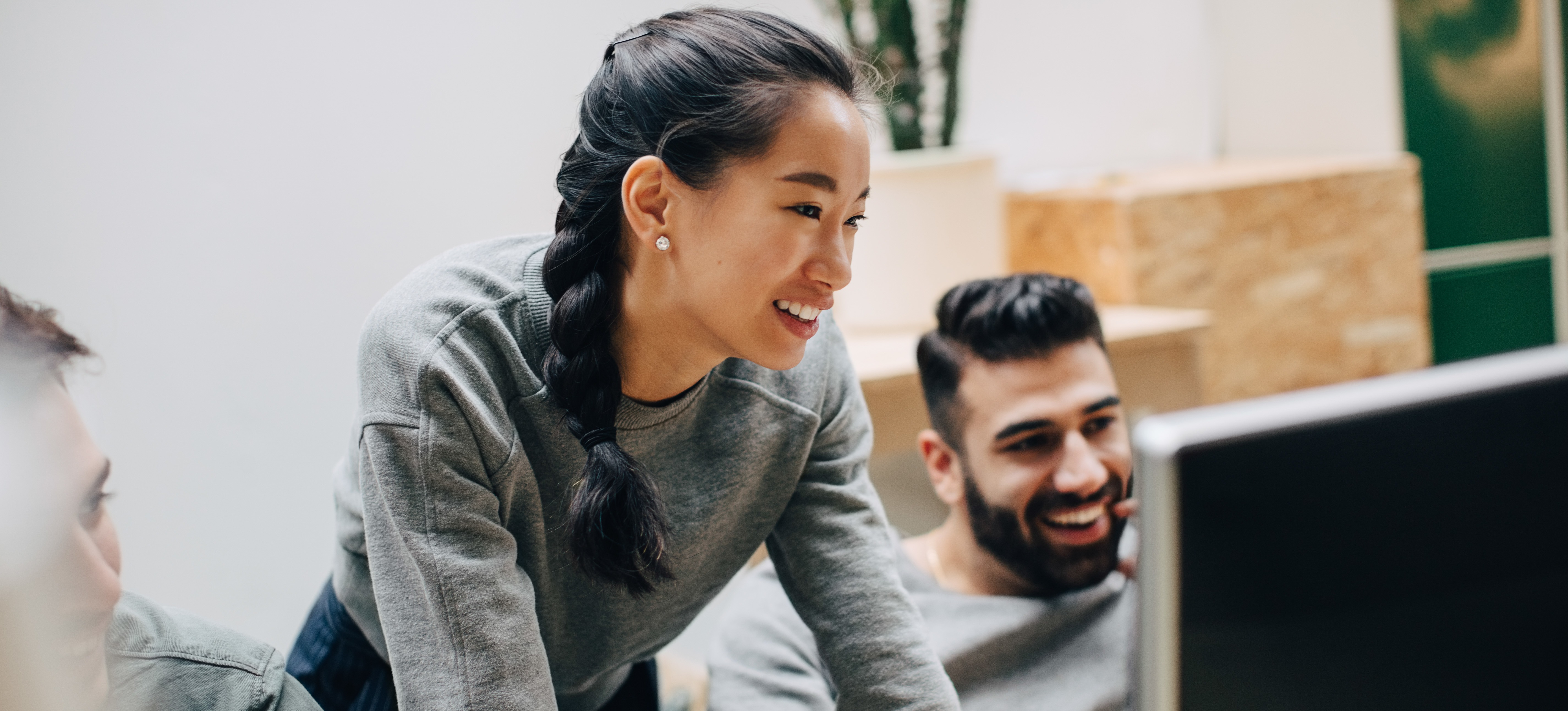 [Featured Image] A c++ developer is sharing a project with a co-worker of an application to help improve a system.