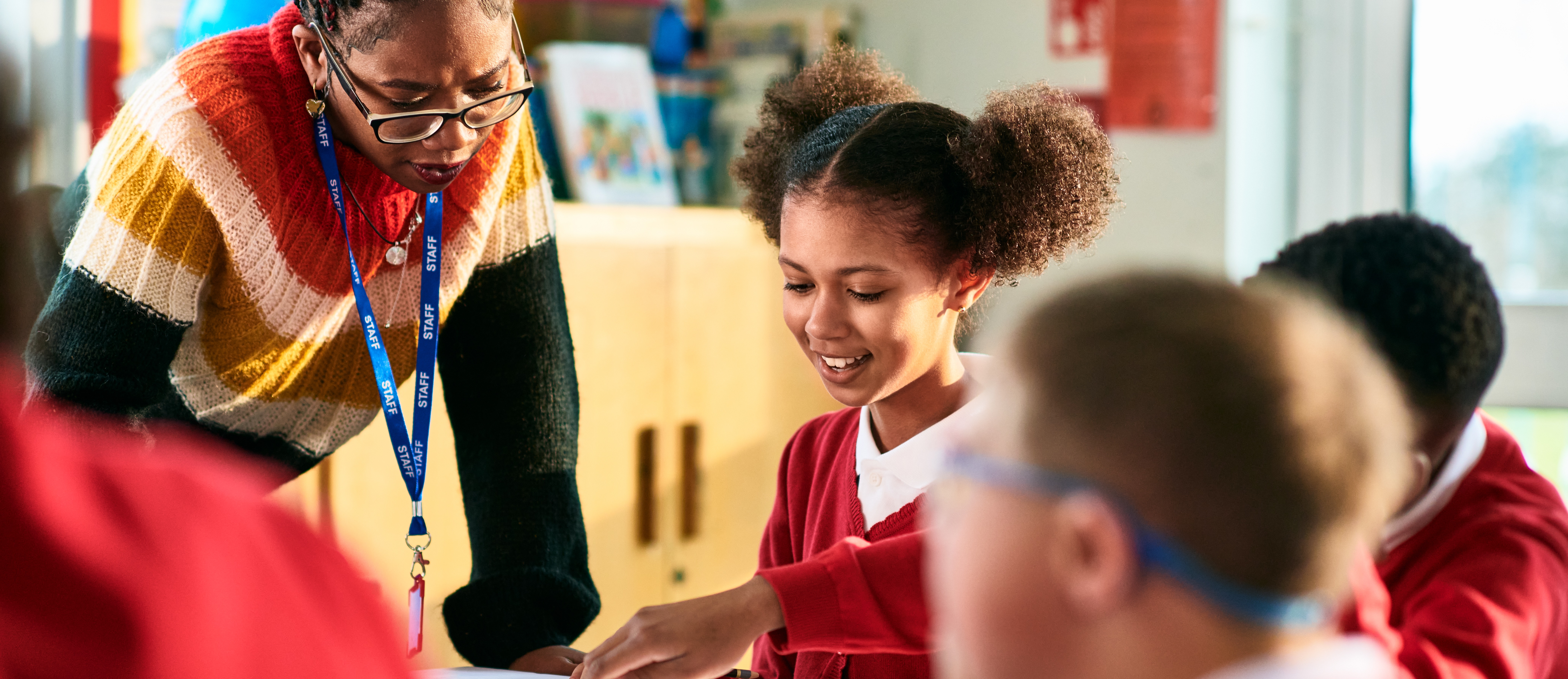 [Featured image]: A teacher provides individualized instruction to a student after implementing machine learning for education tools.
