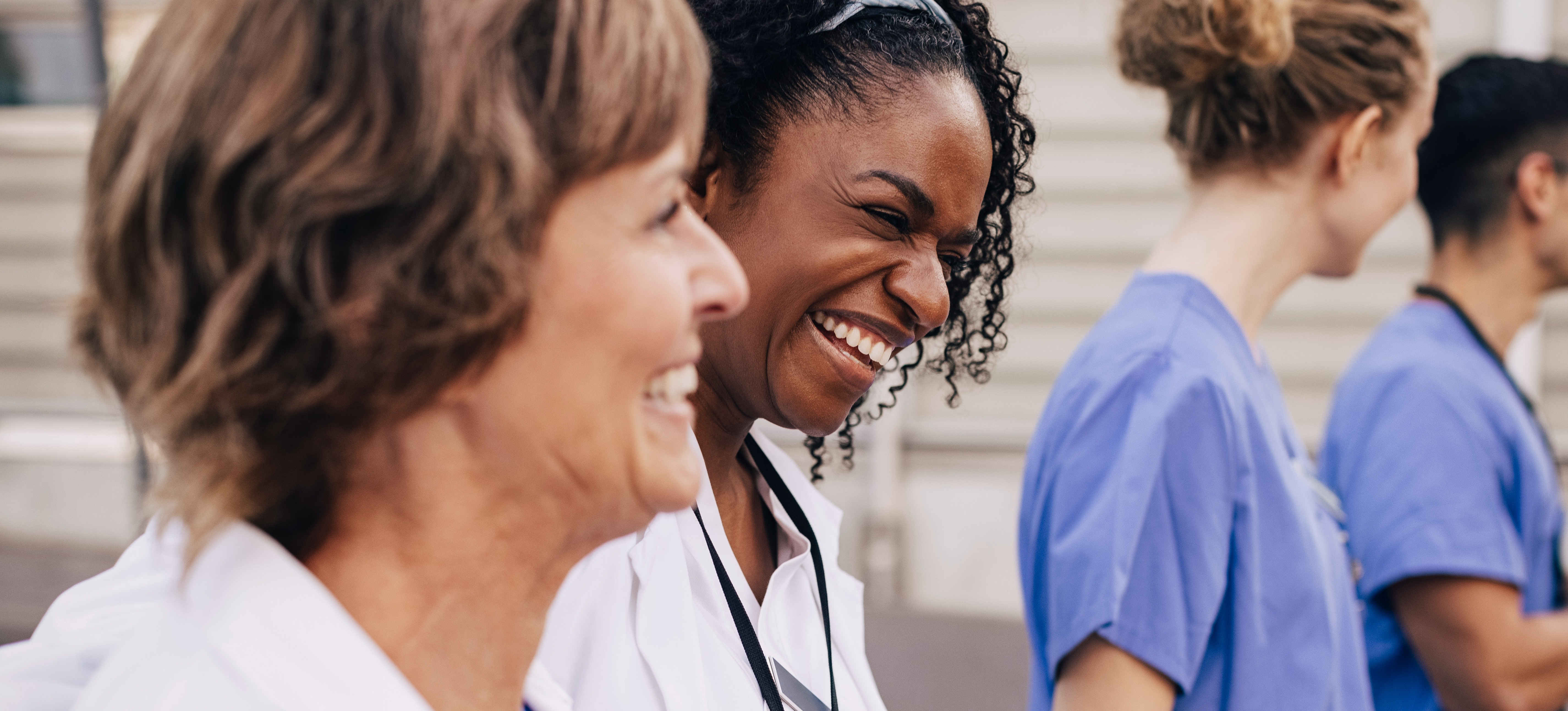 [Featured Image] Medical professionals smile together as they build successful careers that began by researching jobs in the medical field.
