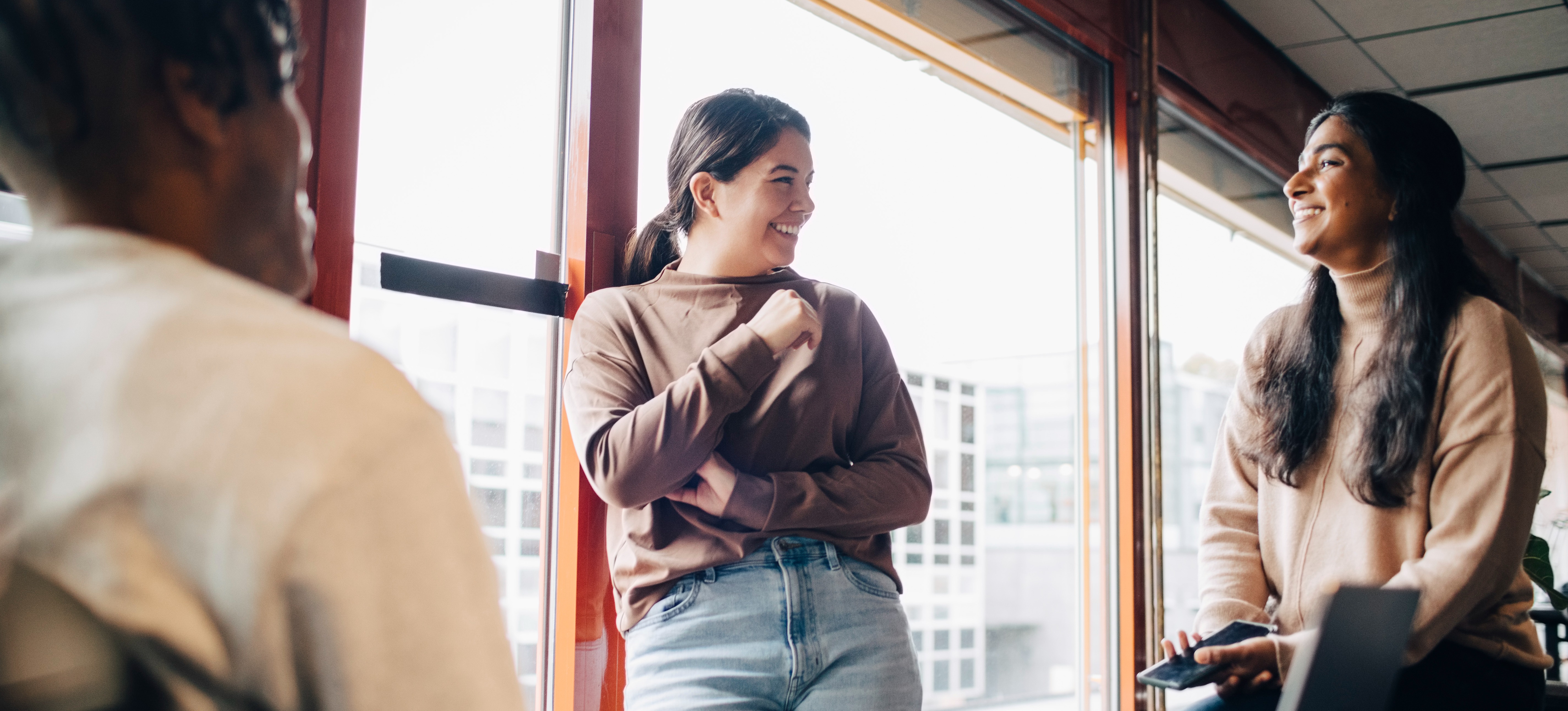 [Feature Image] Three computer science learners smile as they discuss the typical predictive analytics career path and the types of jobs they each want to strive for.
