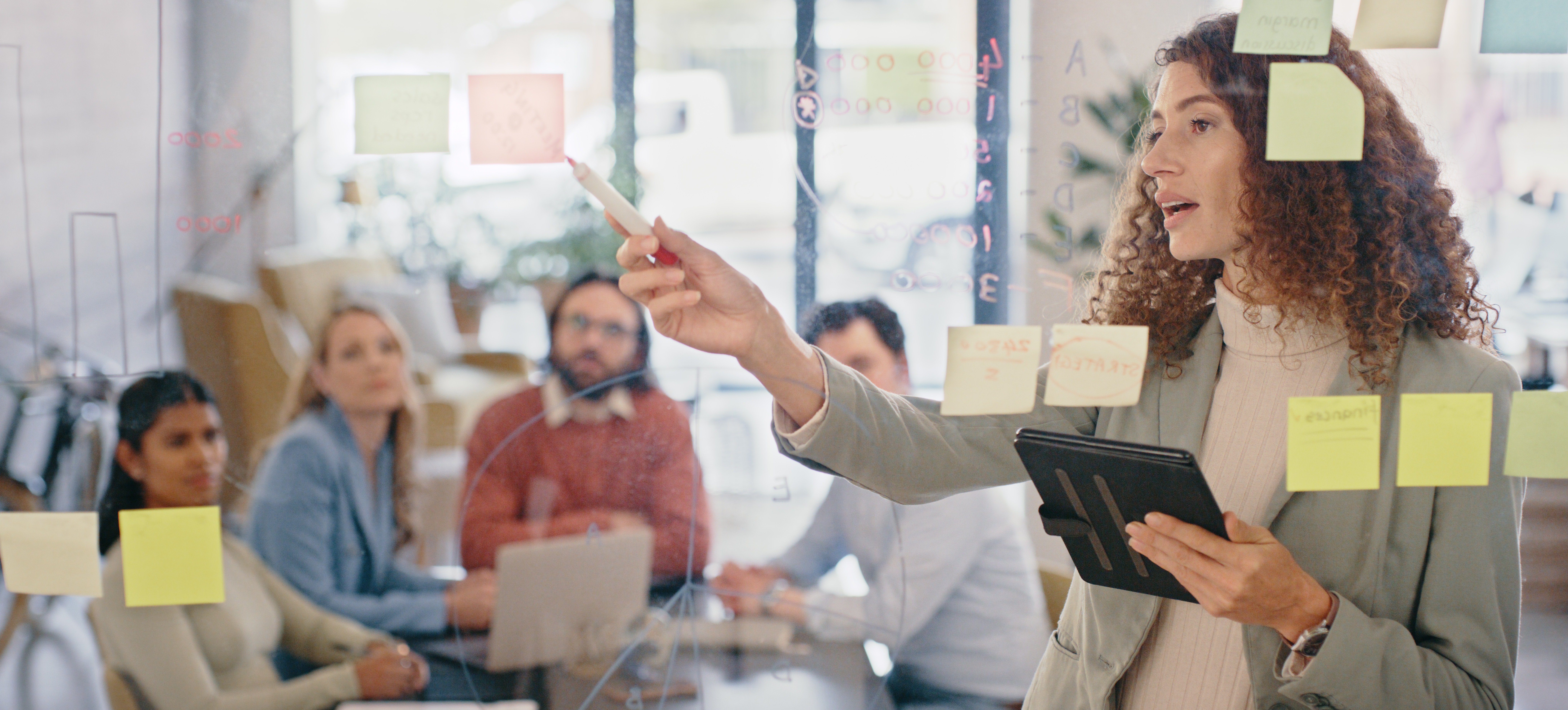 [Image en vedette] Un chef de projet explique à son équipe les étapes à suivre pour mener à bien un projet à venir.
