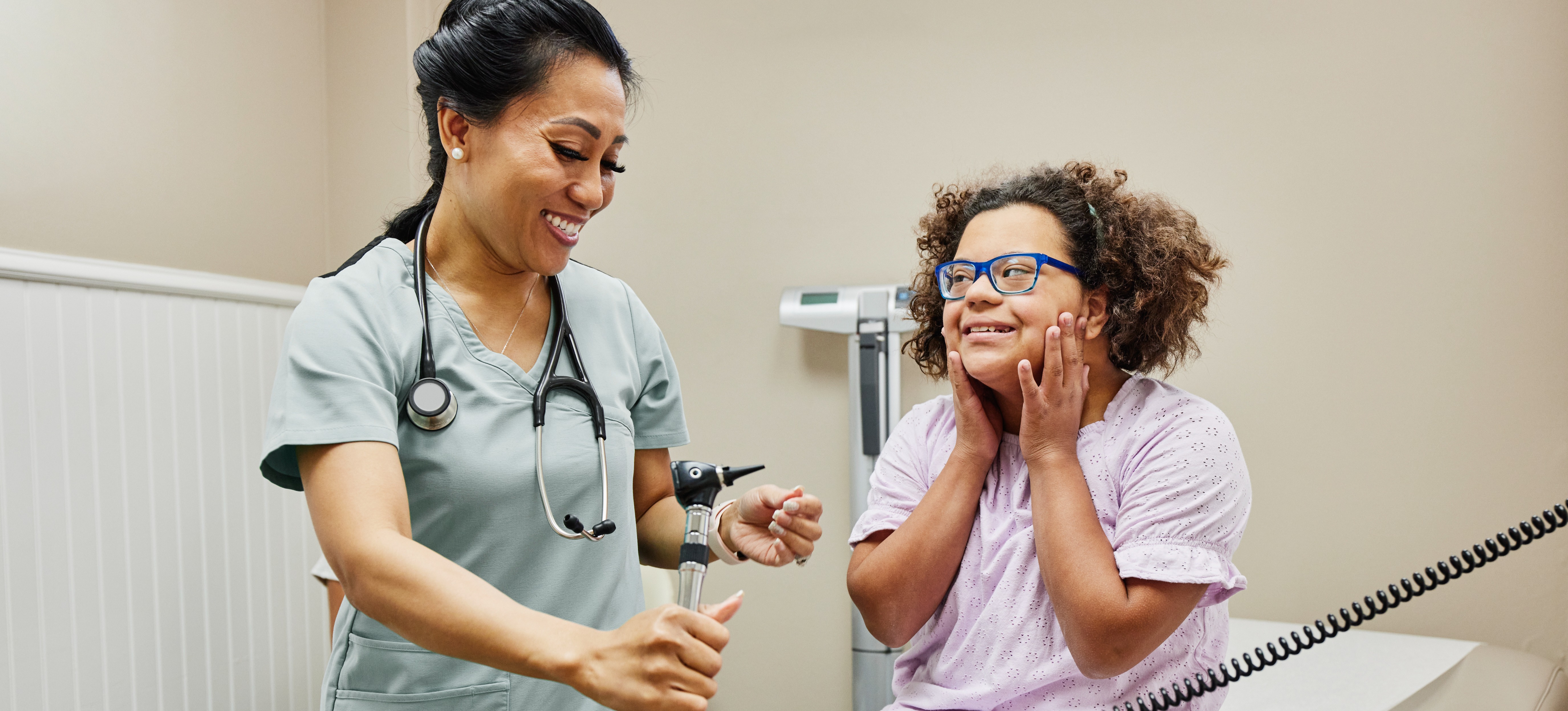 [Featured Image] After learning how to become a licensed practical nurse and achieving the proper qualifications, an LPN takes the vitals of a young patient in an exam room.  
