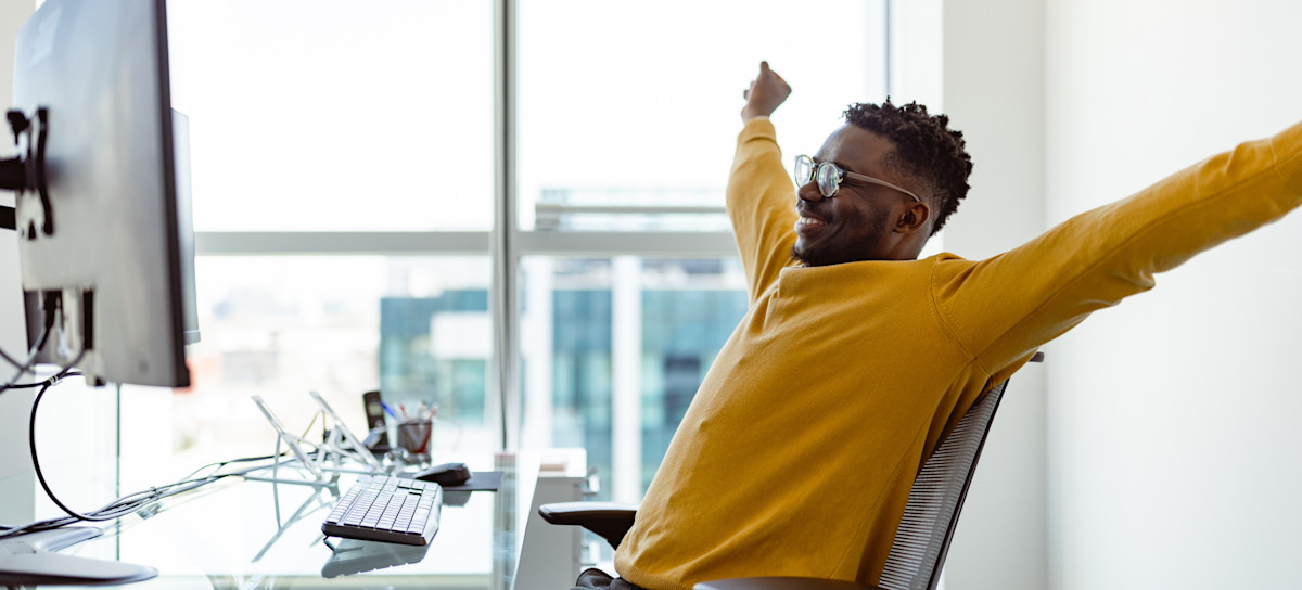 [Featured image] A content creator stretches before resuming using Adobe Express to help them design their next project.
