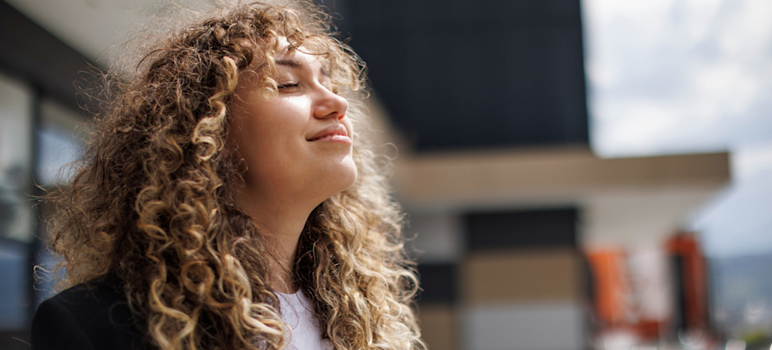 [Featured Image] A confident worker leaves their job after overcoming imposter syndrome during a successful day at work.
