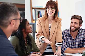 [Featured image] A team of marketers goes over a market analysis report in a brightly lit conference room.