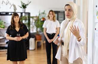 [Featured image] Woman giving a presentation on how to incorporate findings from data science in marketing campaigns. 
