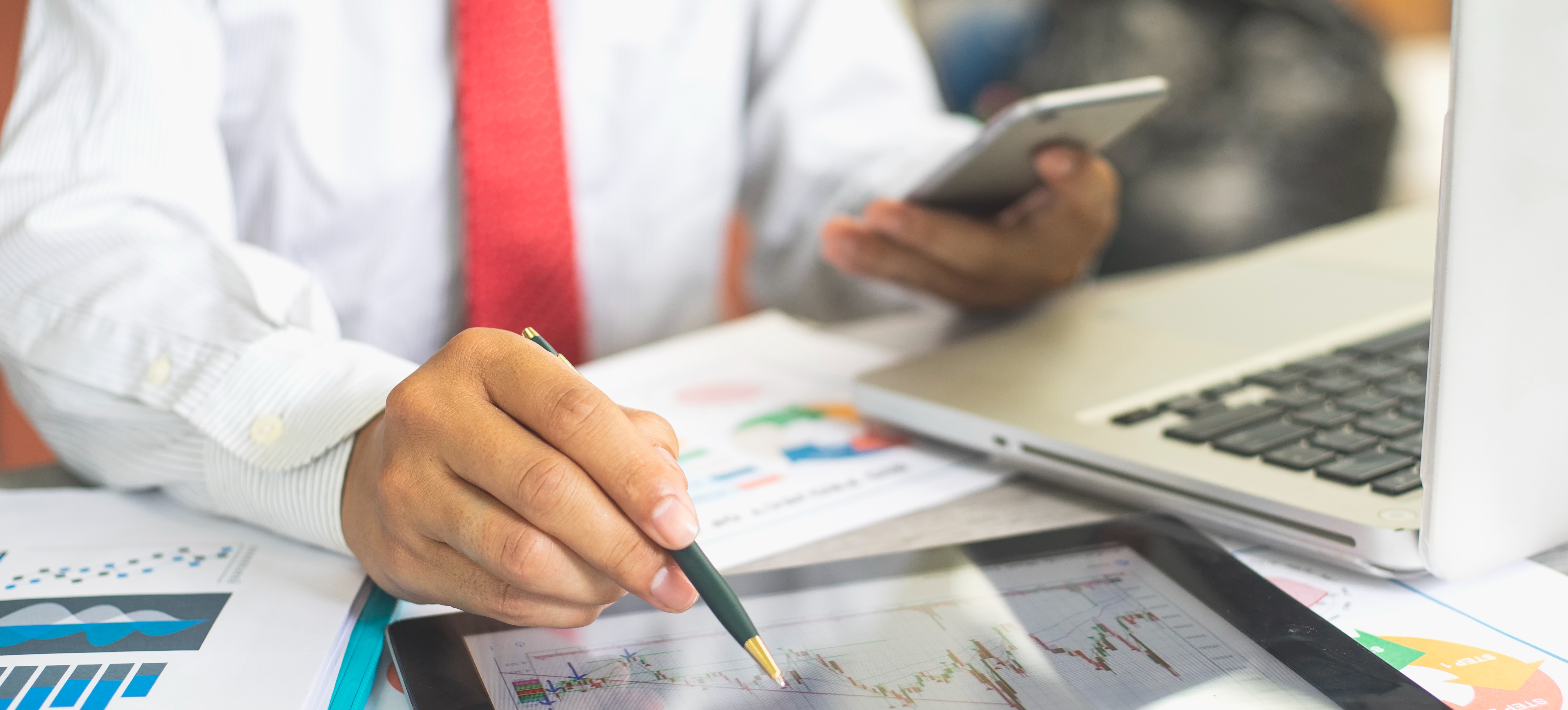 [Featured Image] The hands of a businessman are holding reports of data acquired through clustering in data mining.