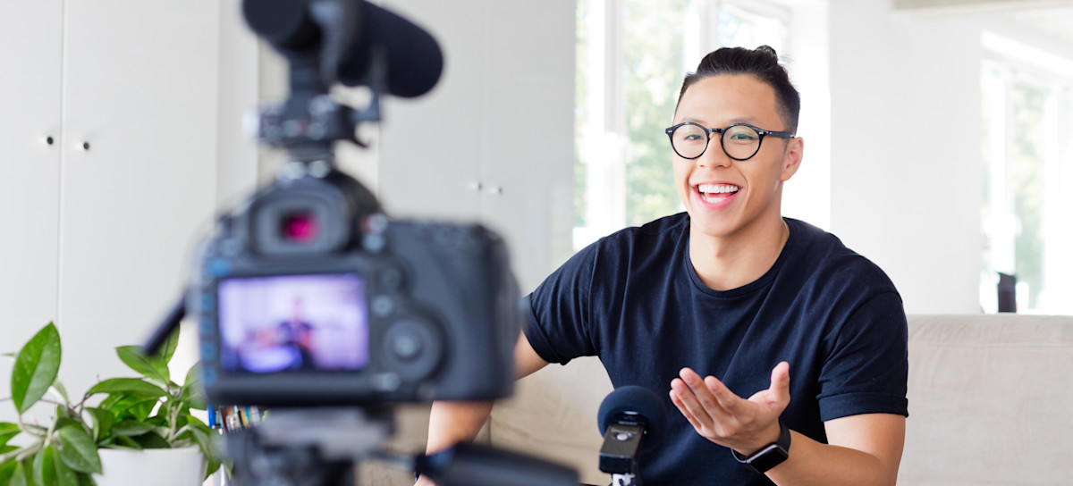 [Featured Image] Person with a top bun and round glasses speaks in front of a camera in their living room.