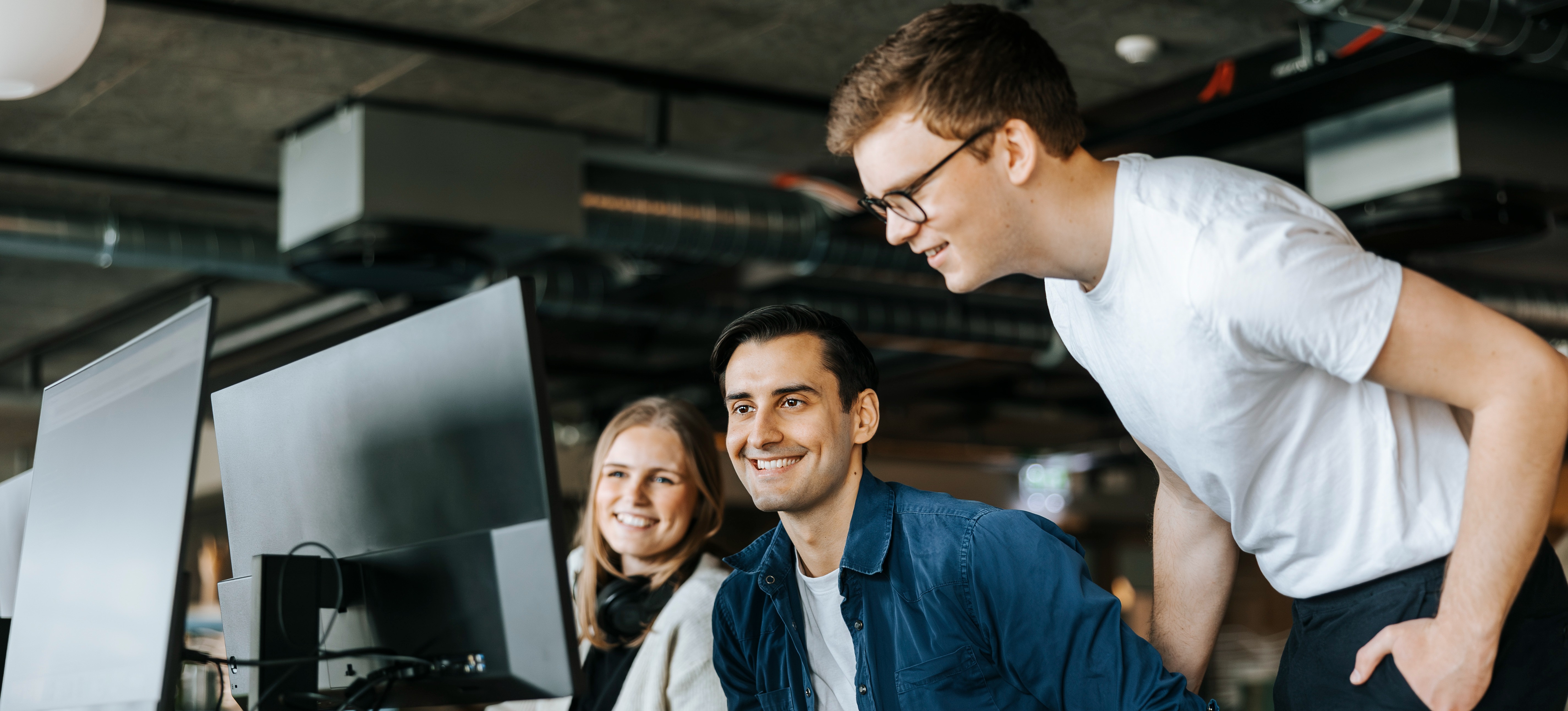 [Featured Image] A technical project management team in an office celebrates their leader getting their certification.
