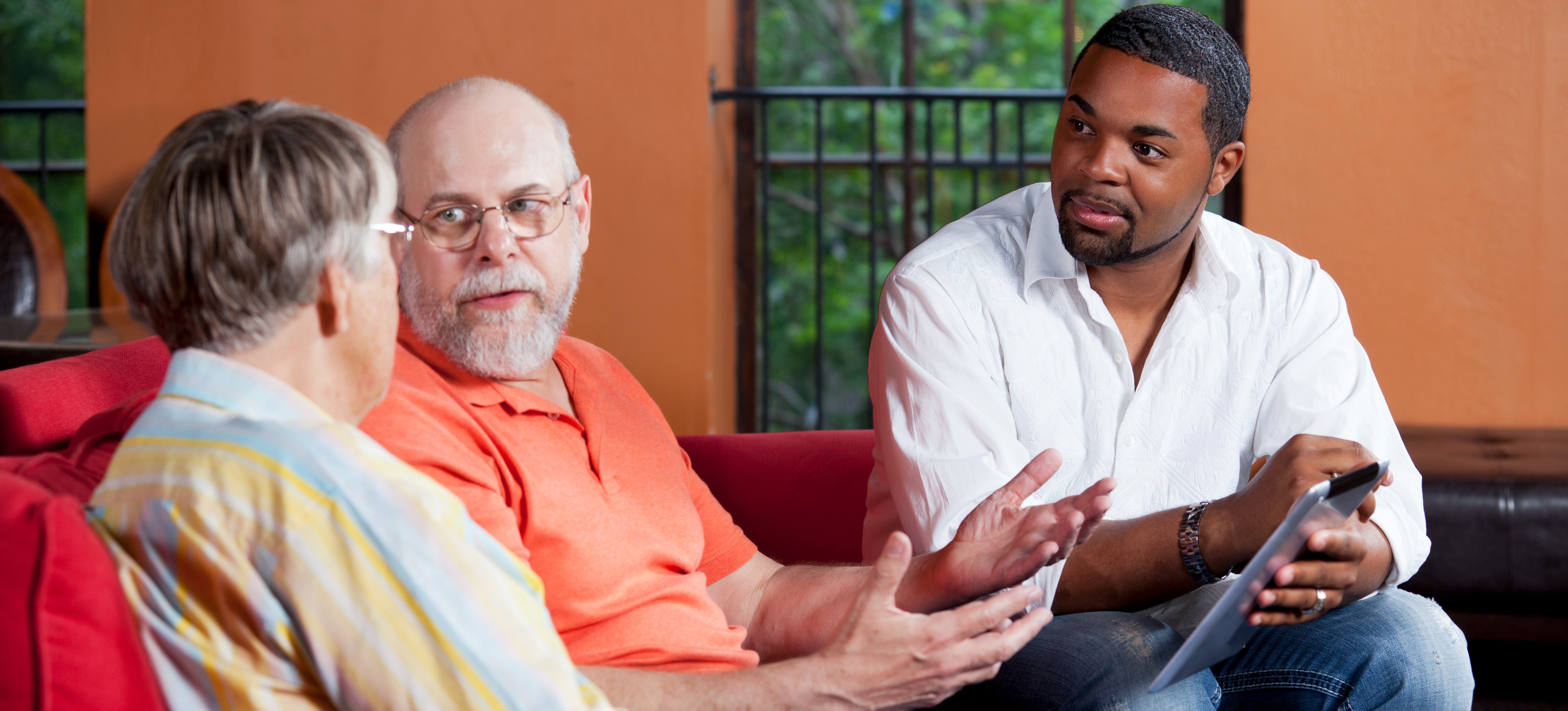 [Featured Image] A community health worker consults with two members of his community.
