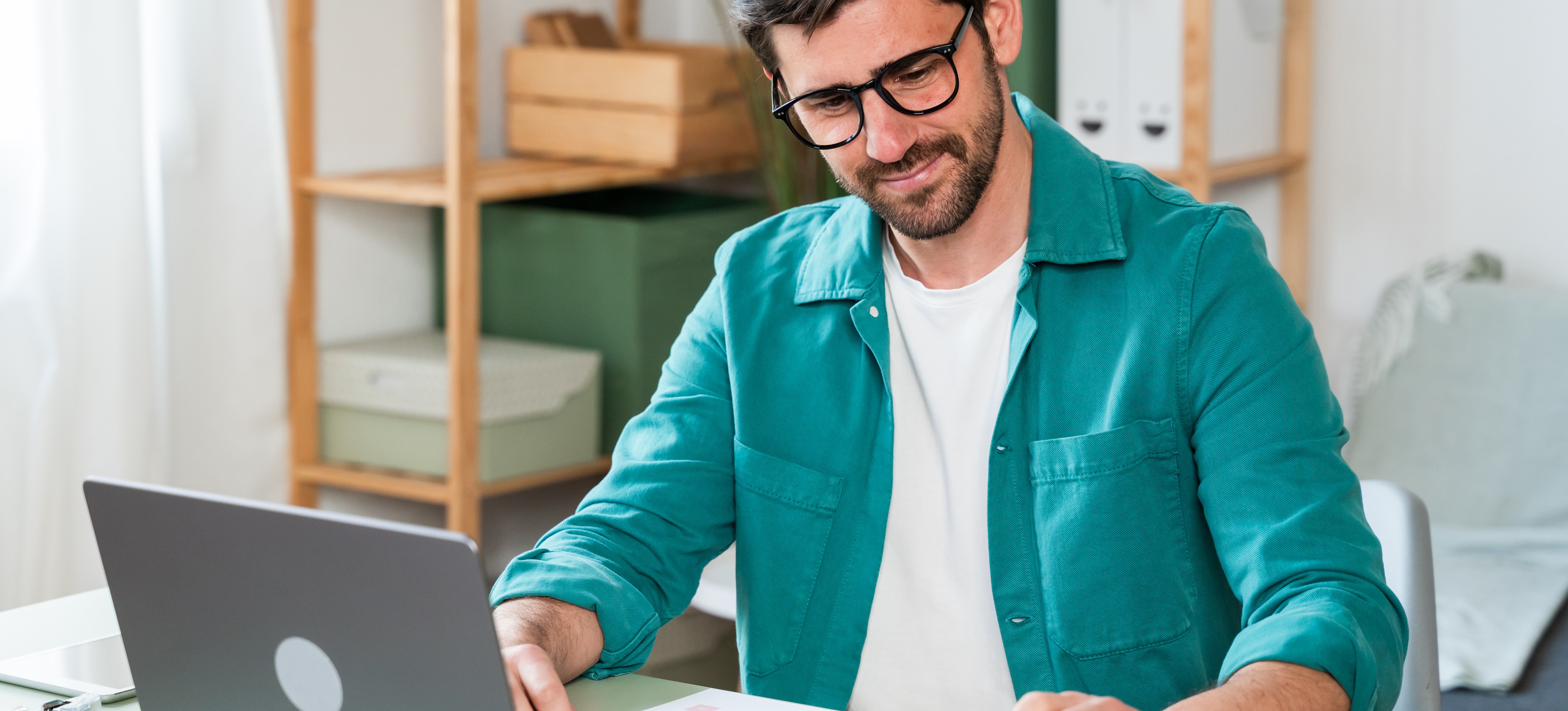 [Featured Image] A tax specialist sits at a desk and uses a calculator and laptop to calculate a client's taxes.

