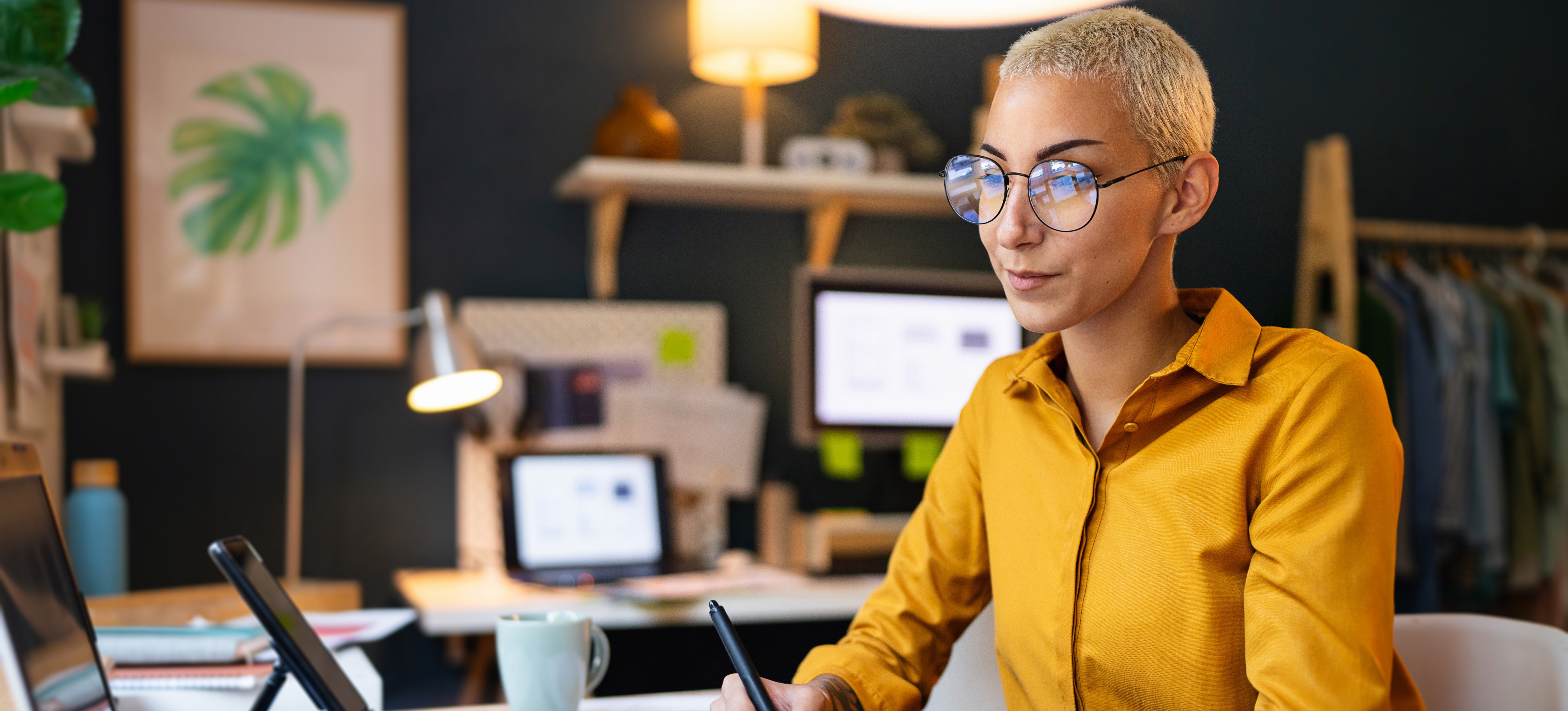 [Featured image]: A product designer with a stylus and laptop, using prototyping tools to develop a mockup.
